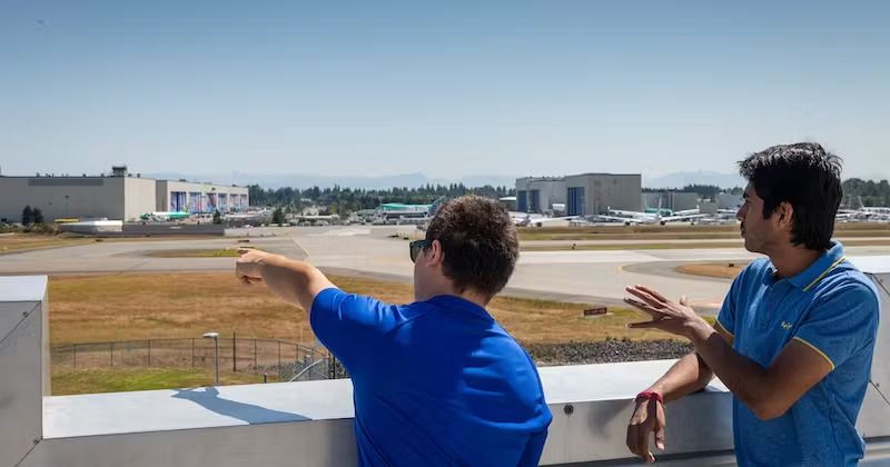 Two individuals looking at aircraft while standing on the Boeing Everett Sky Deck.