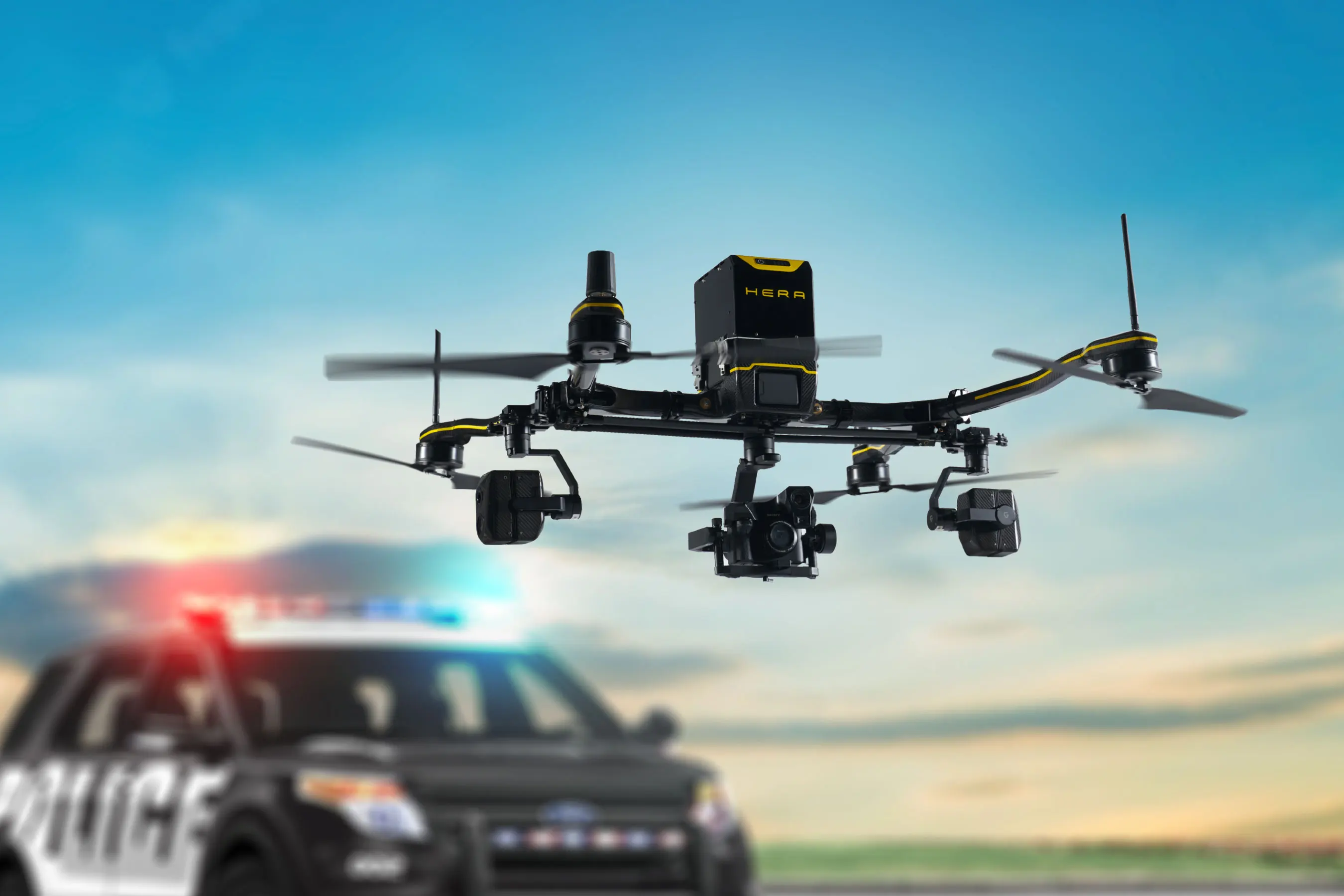 A RMUS Heavy Duty Law Enforcement Drone Flying in front of a police car.