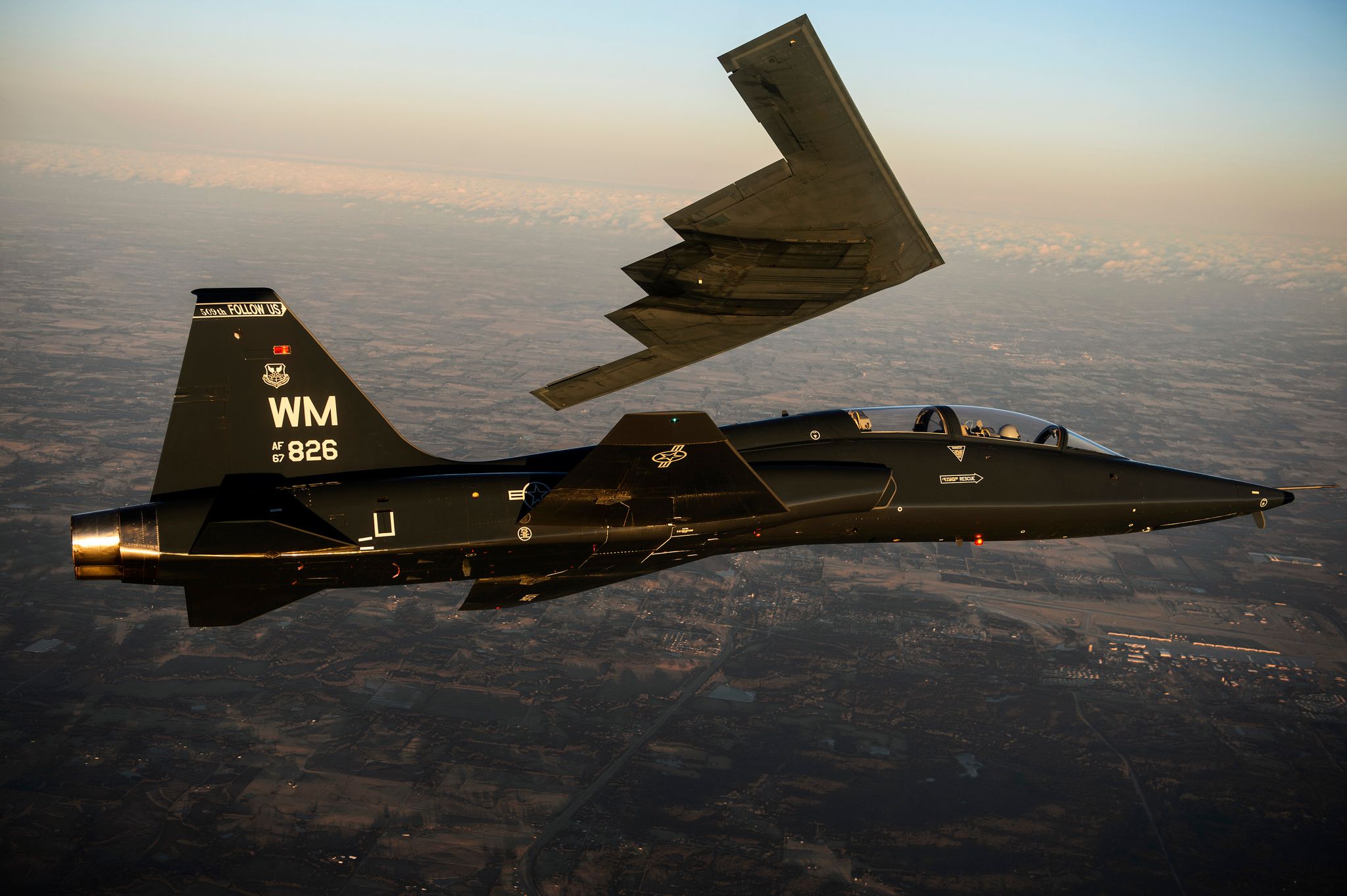 A T-38 Talon flies in formation with the B-2 Spirit of South Carolina during a training mission over Whiteman Air Force Base 