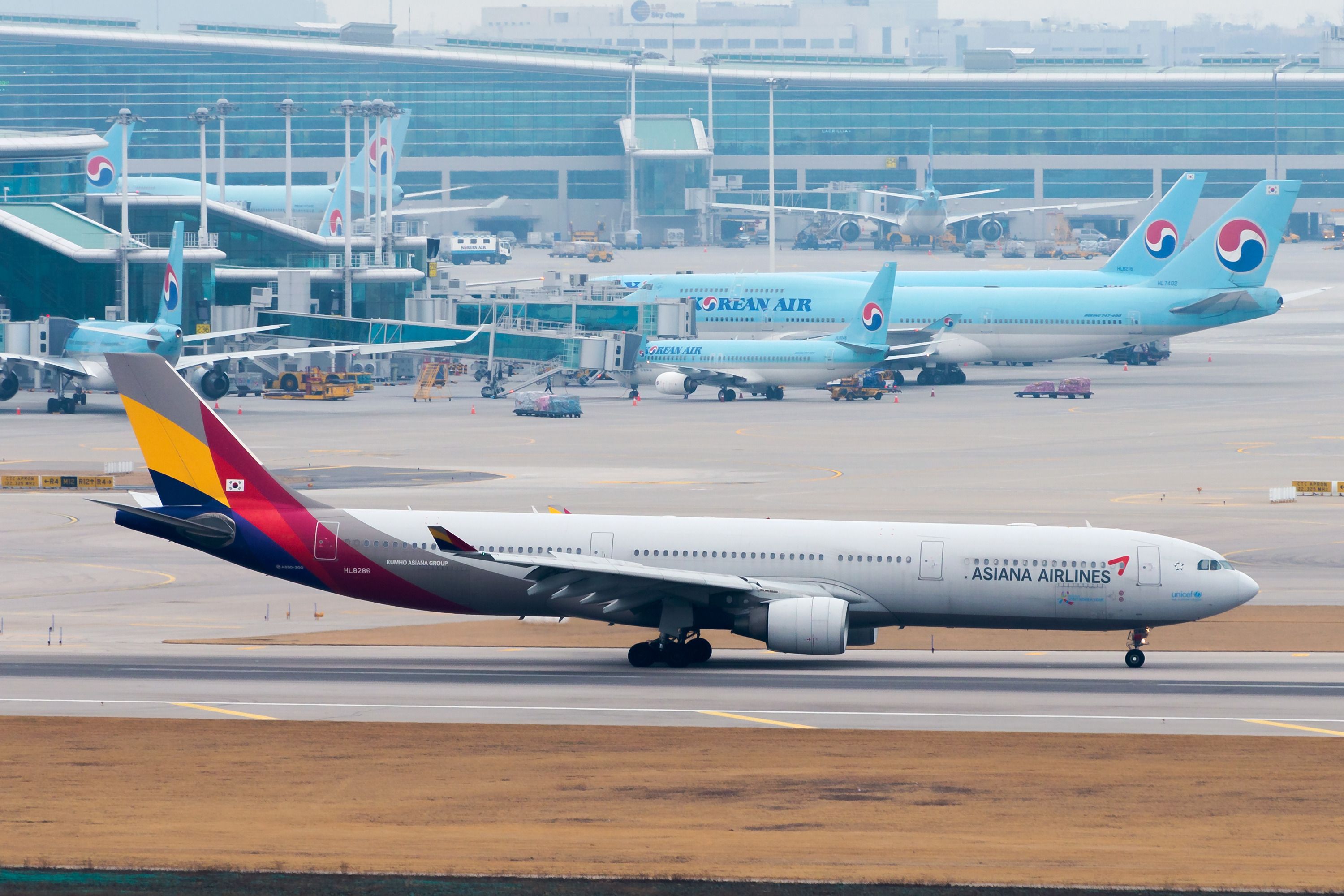 An Asiana Airlines Airbus A380 and multiple Korean aircraft behind 