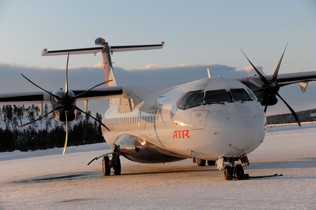 An ATR 72-600 parked on a snowy airport apron.