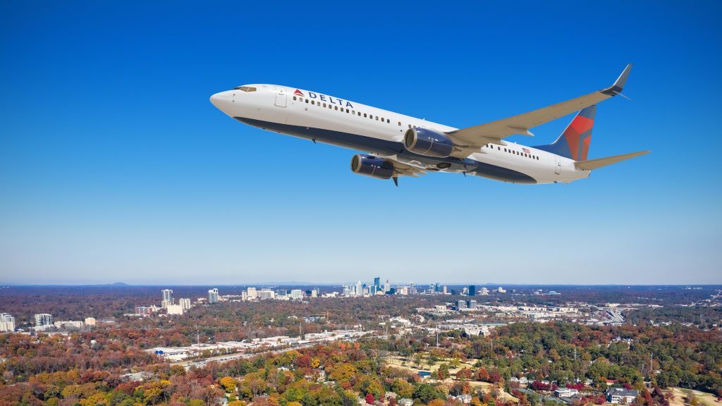 A Delta Air Lines Boeing 737 flying over the city of Atlanta.