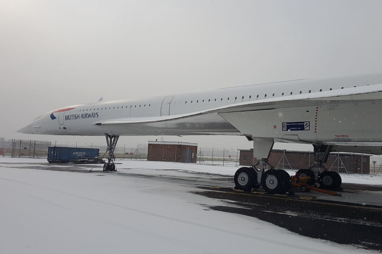 A British Airways Concorde Parked on a snowy airport apron.