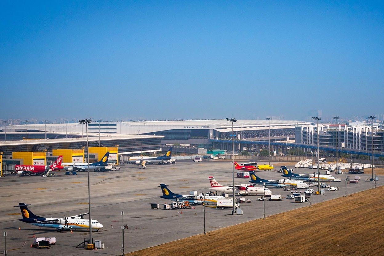 Exterior view of a terminal building with several aircraft parked outside the gates