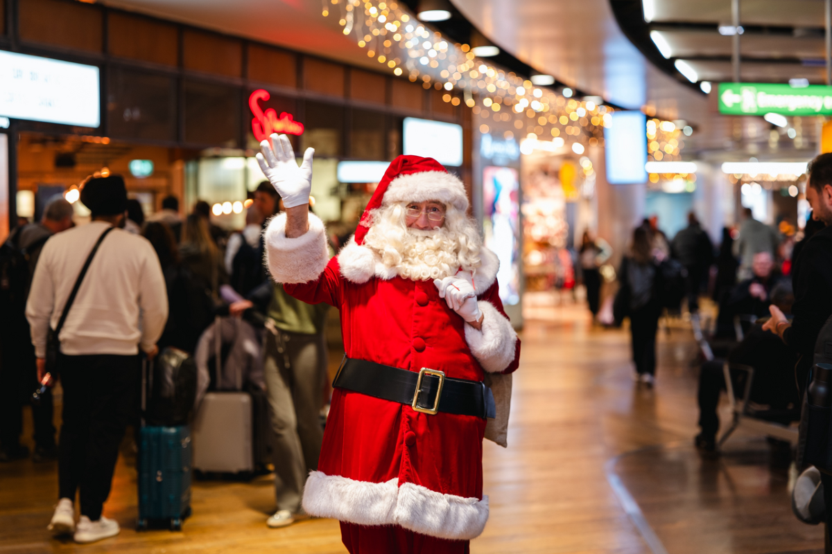 A photo of Santa standing in the main terminal of London Heathrow Airport.