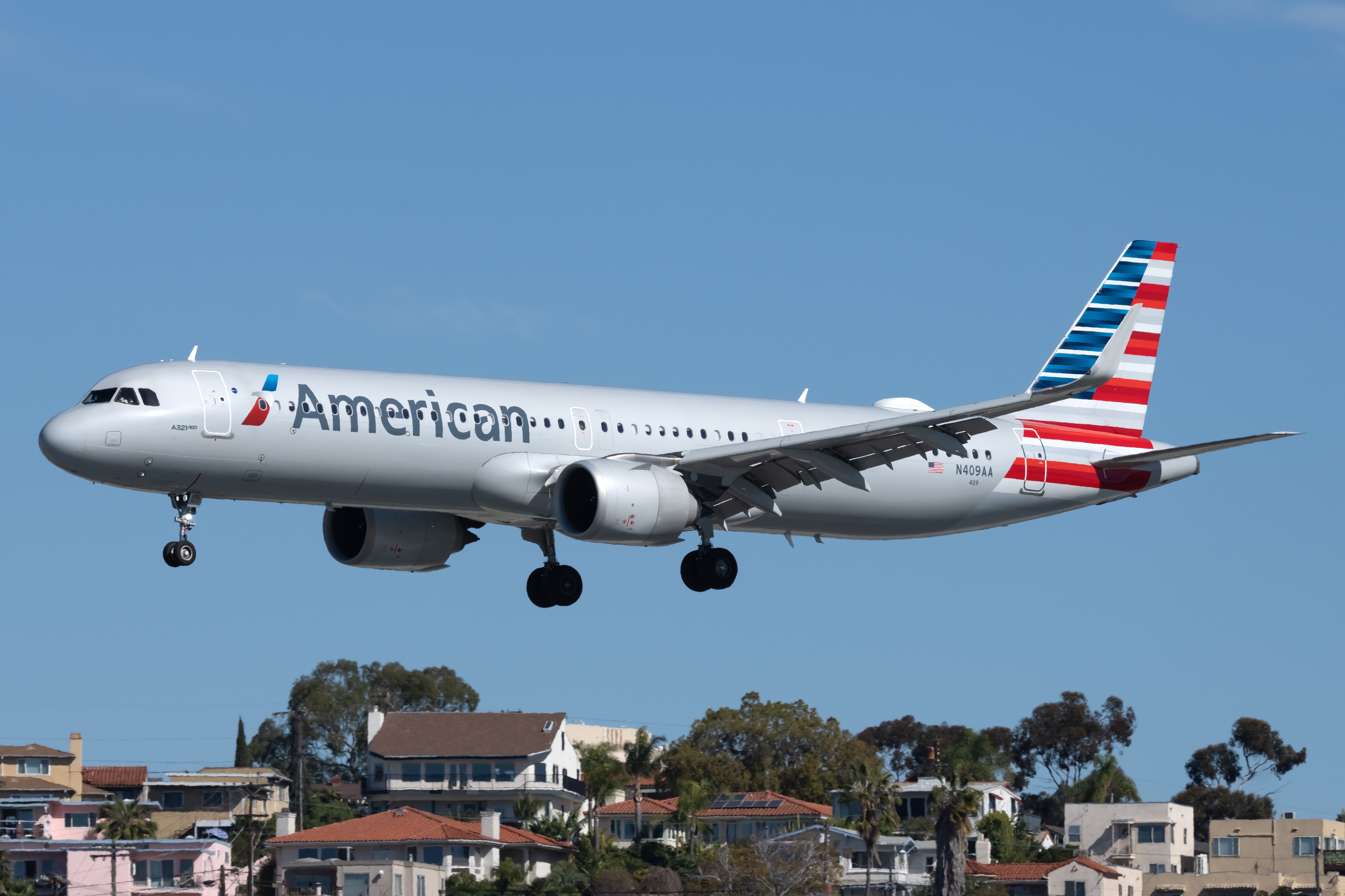 An American Airlines Airbus A321-253NX flying close to the ground.