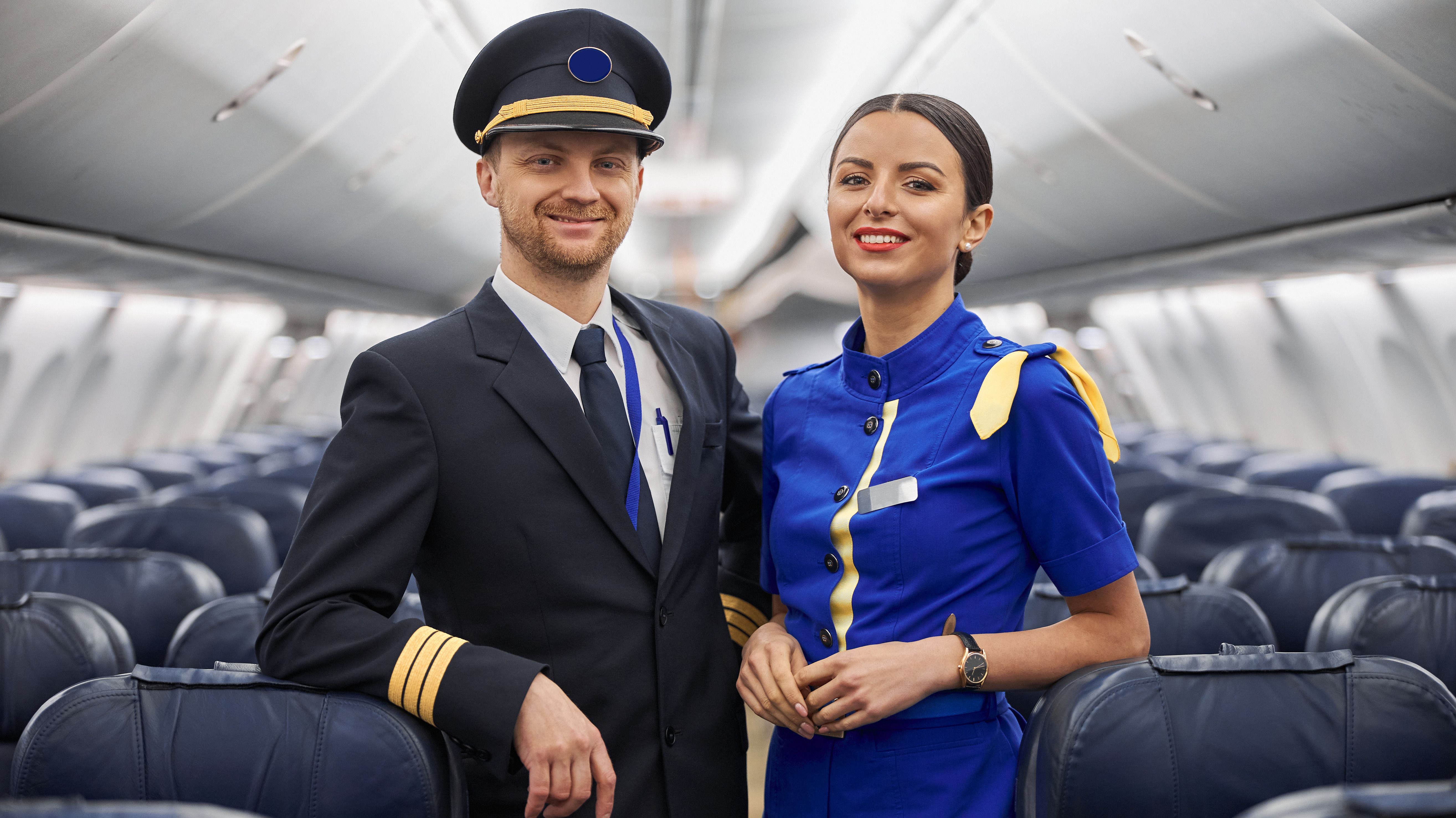 Portrait of a pilot and a cabin crew member inside a plane 