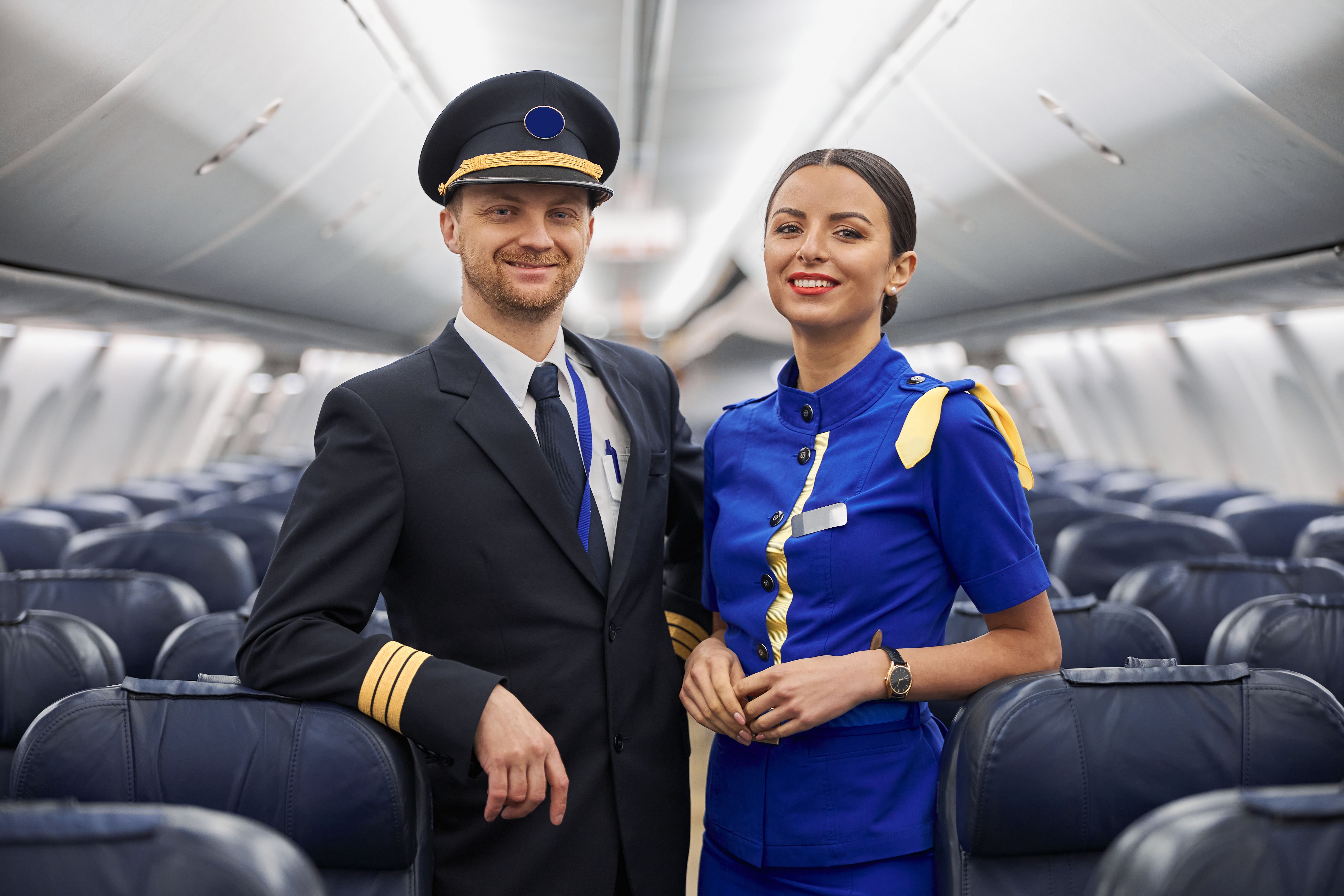 Portrait of a pilot and a cabin crew member inside a plane 