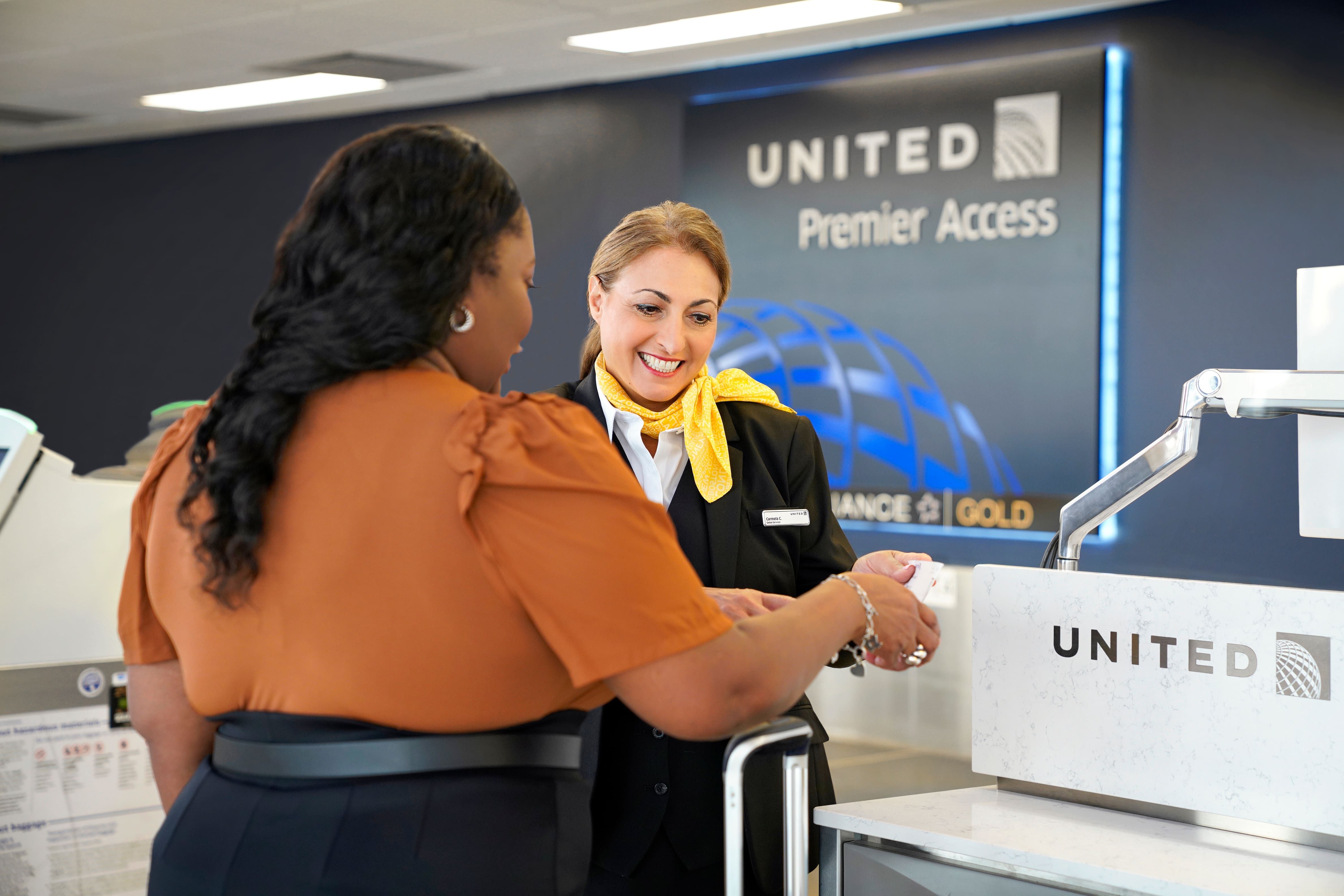 A woman checking in at the United Airlines Premier Access counter