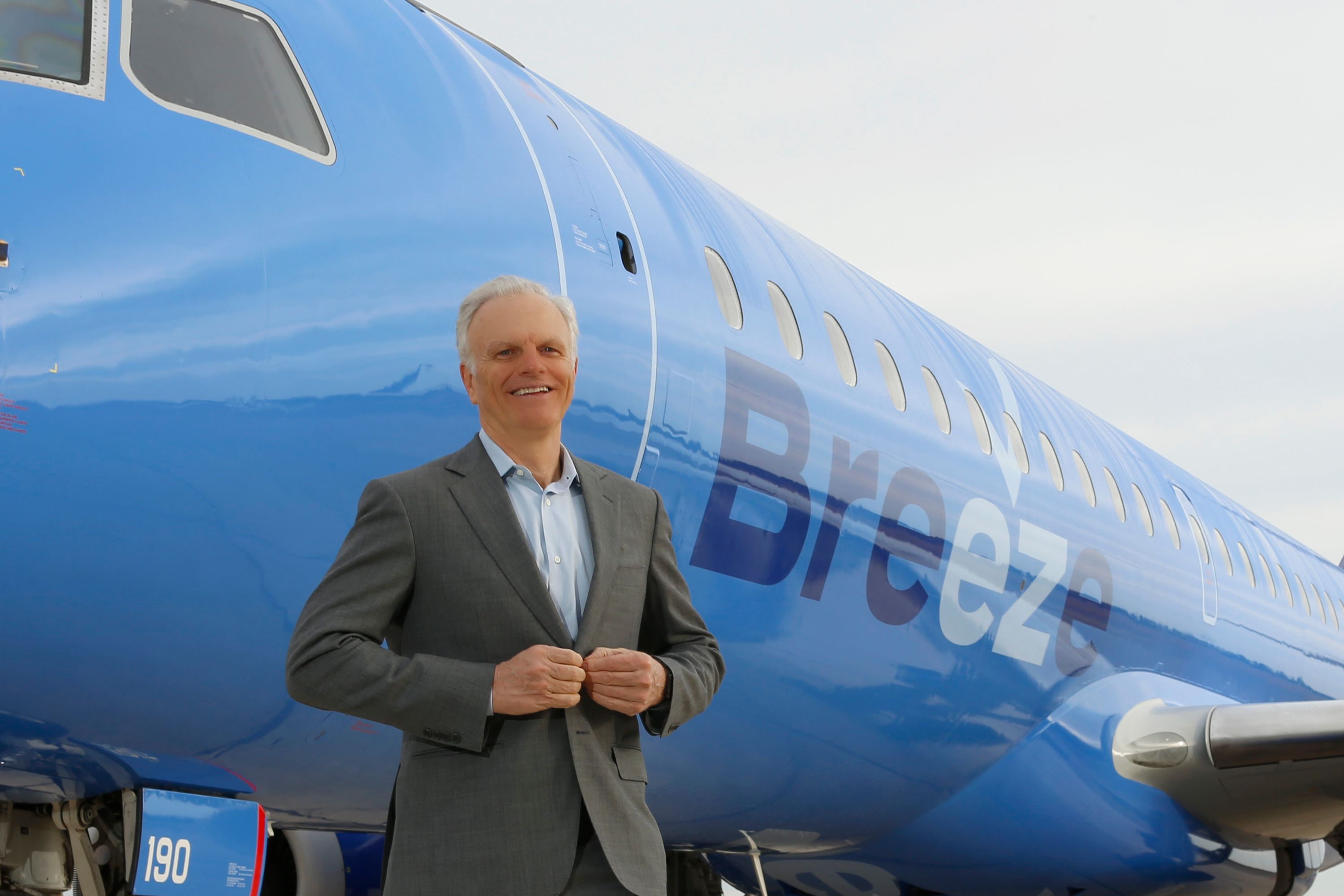 David Neeleman standing in front of a Breeze Airways aircraft.