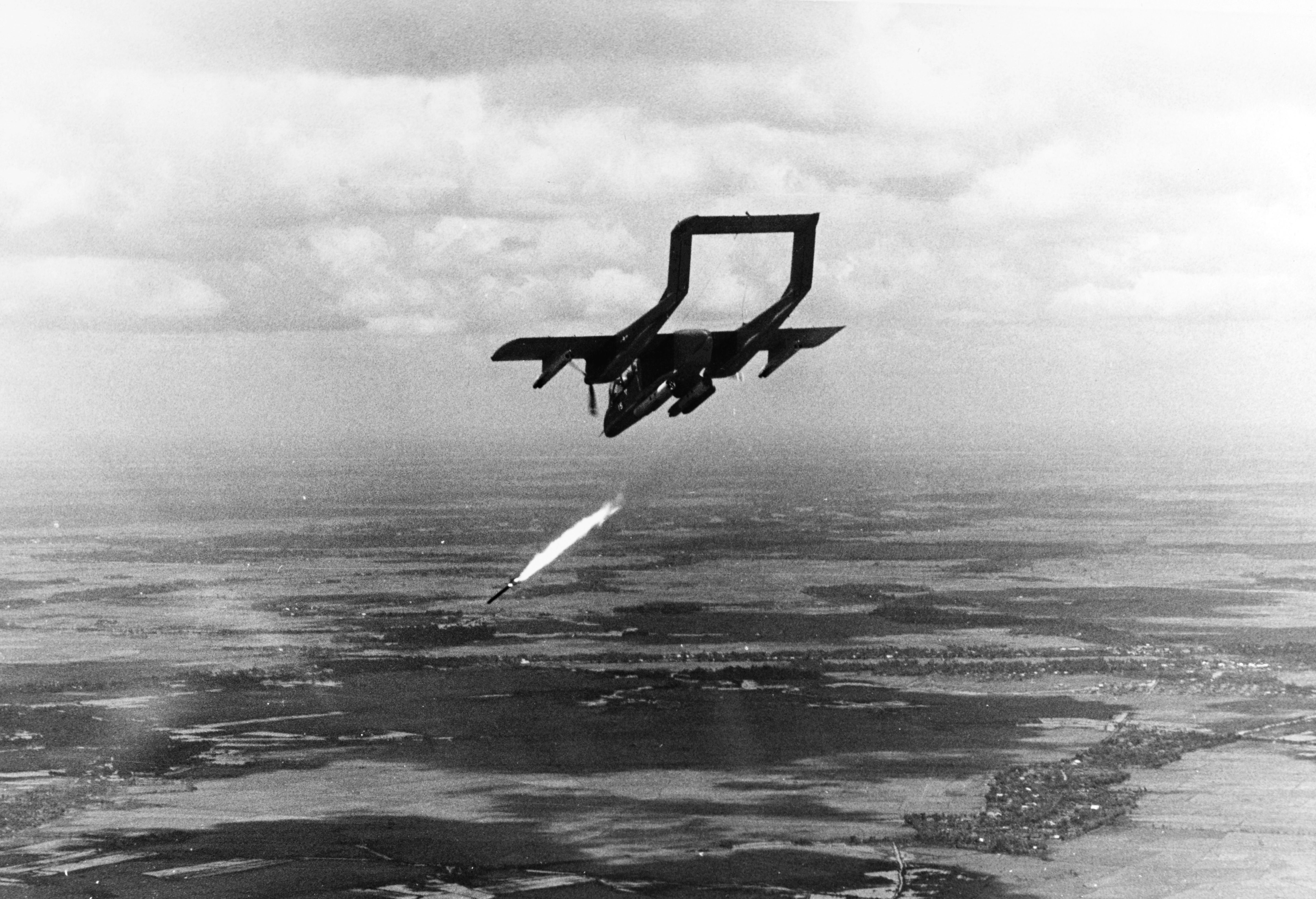 A black and white photo of an OV-10A attacking a target in Vietnam.