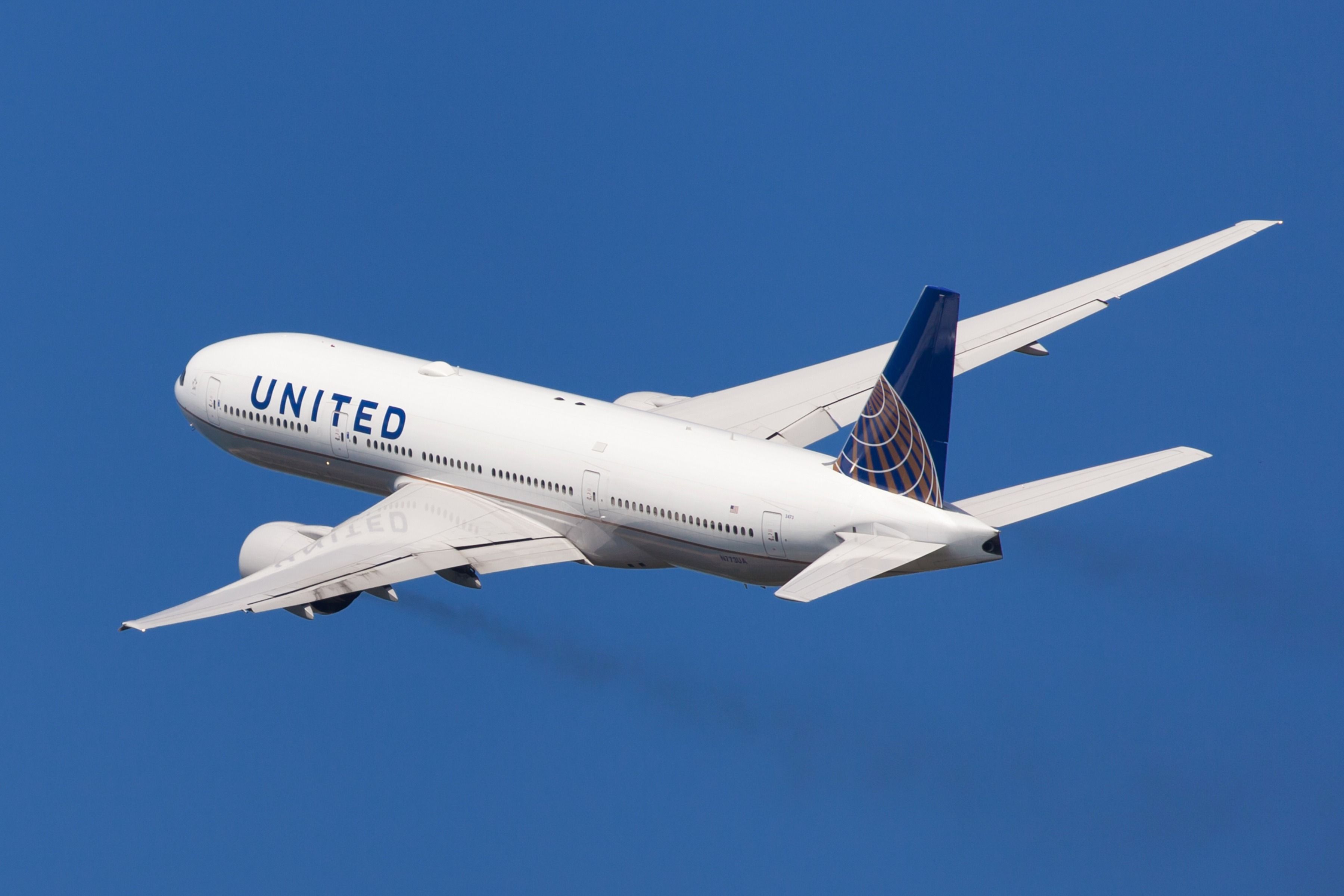 A United Airlines Boeing 777 flying in the sky.