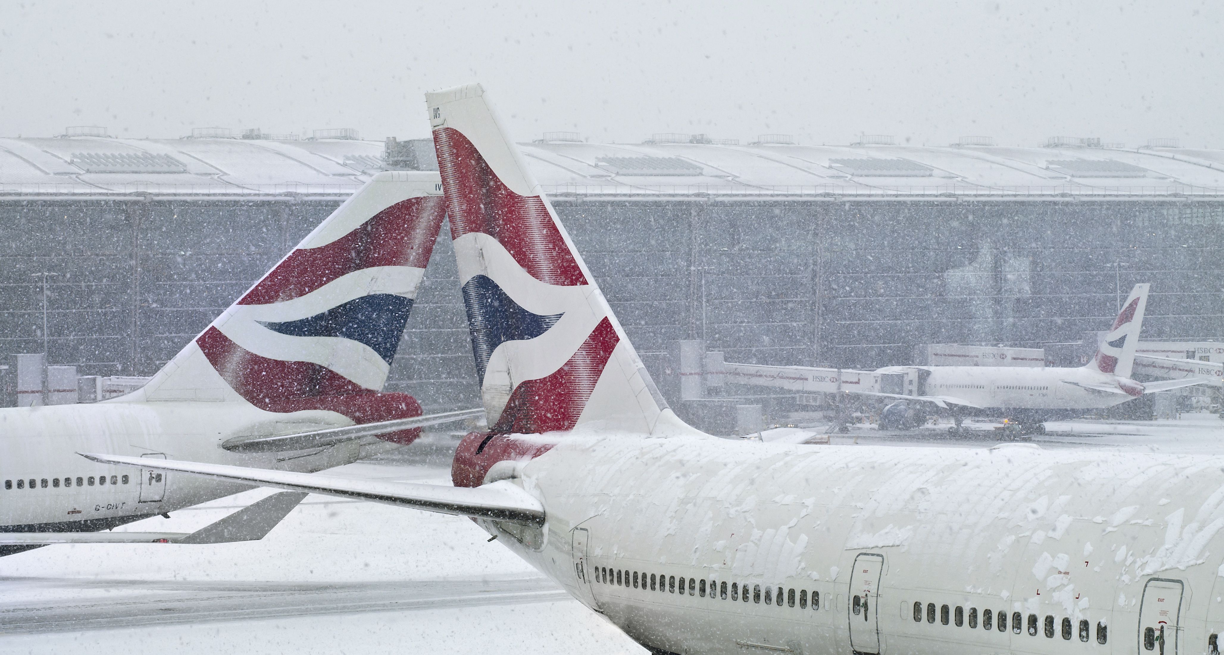 London Heathrow's snowy apron with two aircraft tales