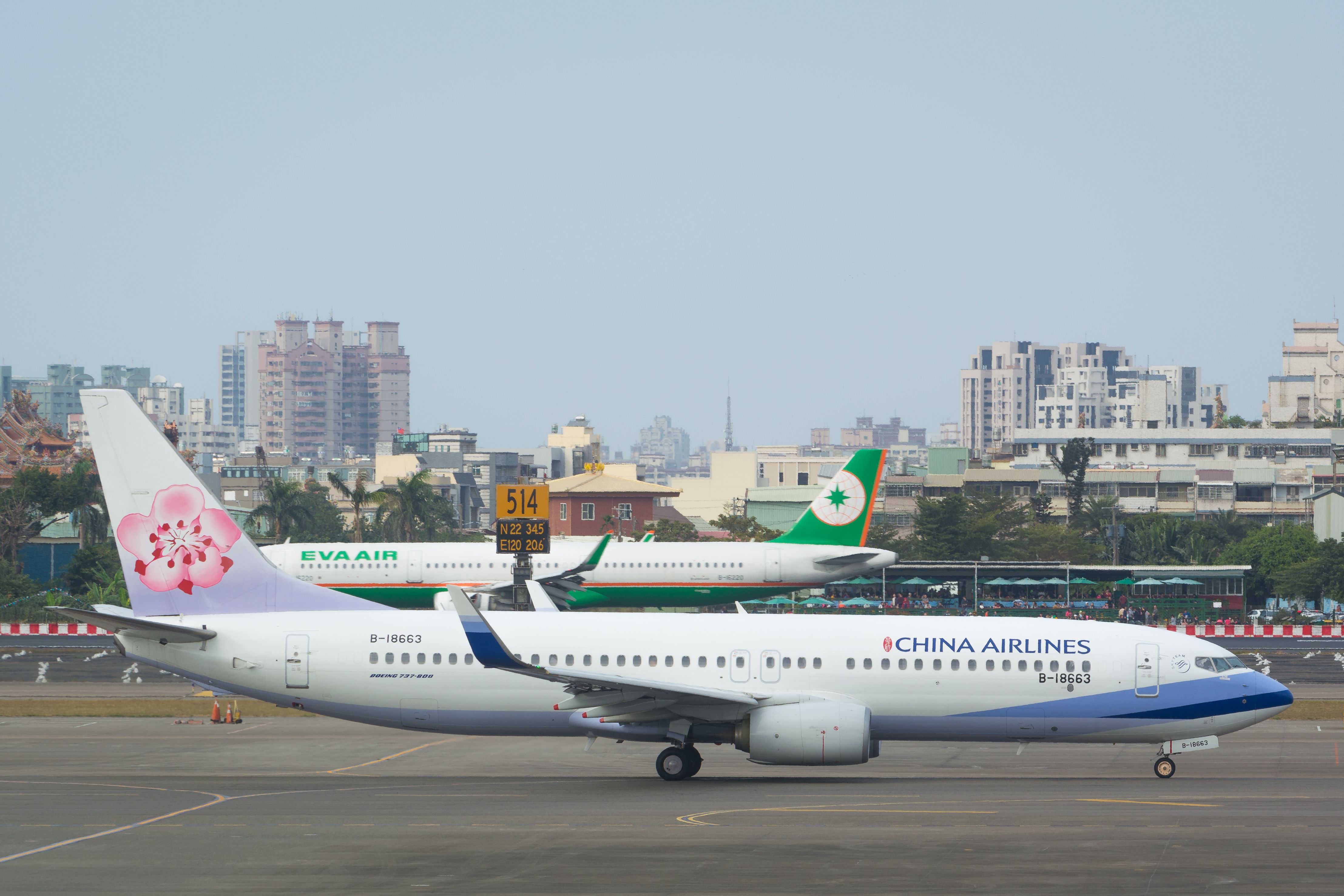 A China Airlines aircraft taxiing in front of an EVA Air aircraft.