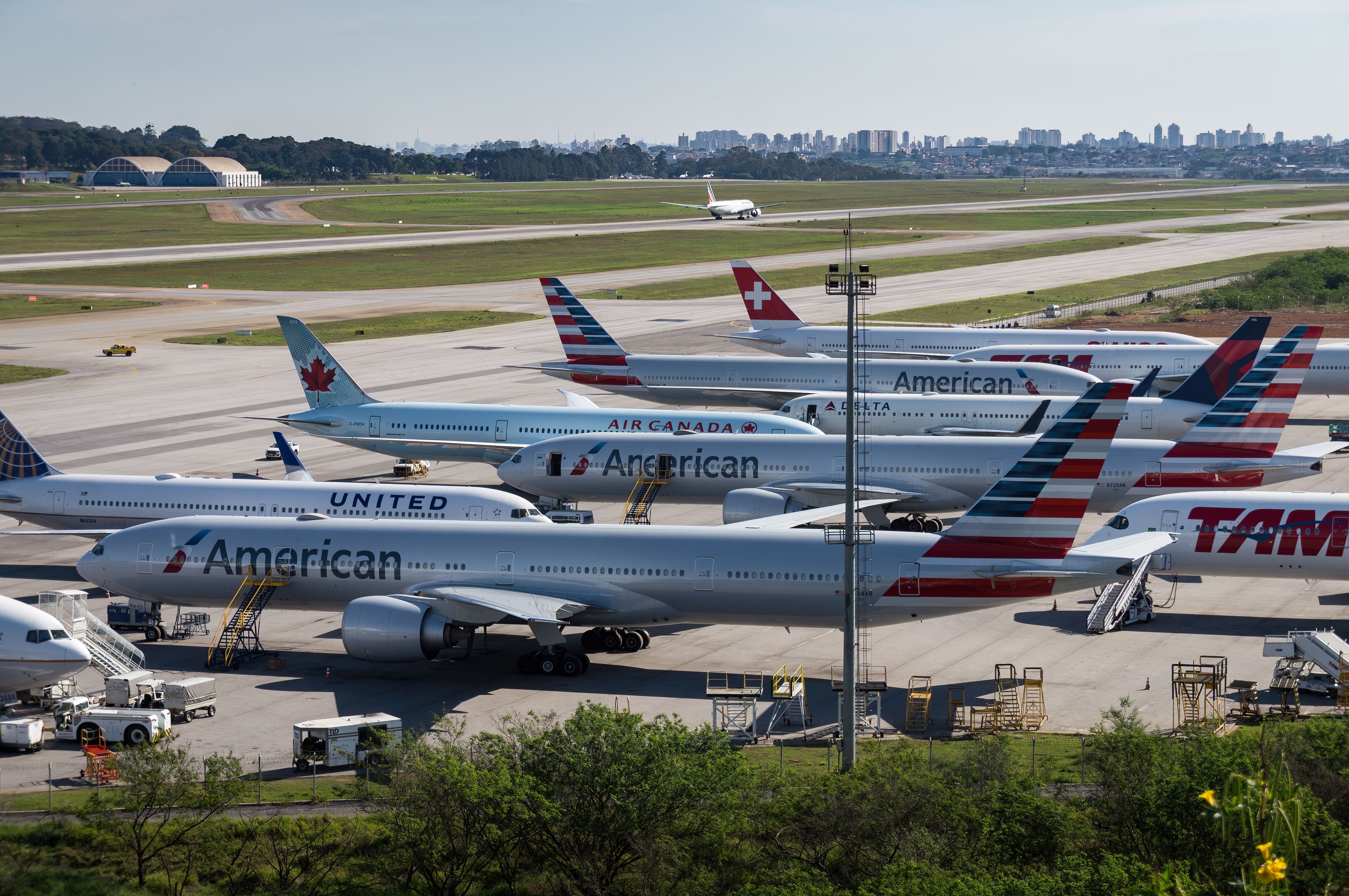 Aircraft of various airlines, such as Unites, American, Air Canada, and SWISS, parked on an airport apron.