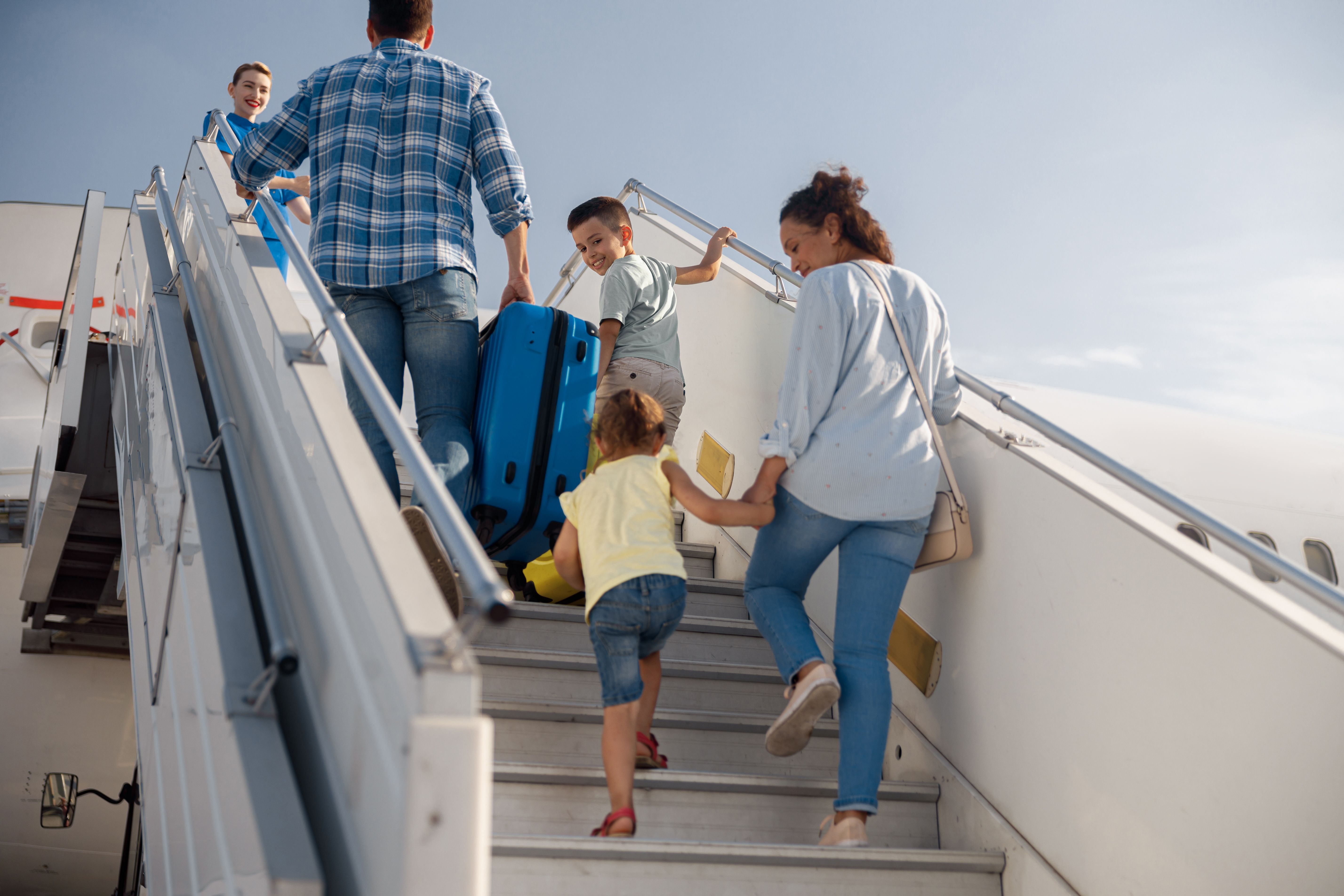 A Father, Mother, and Two Children boarding an aircraft. 