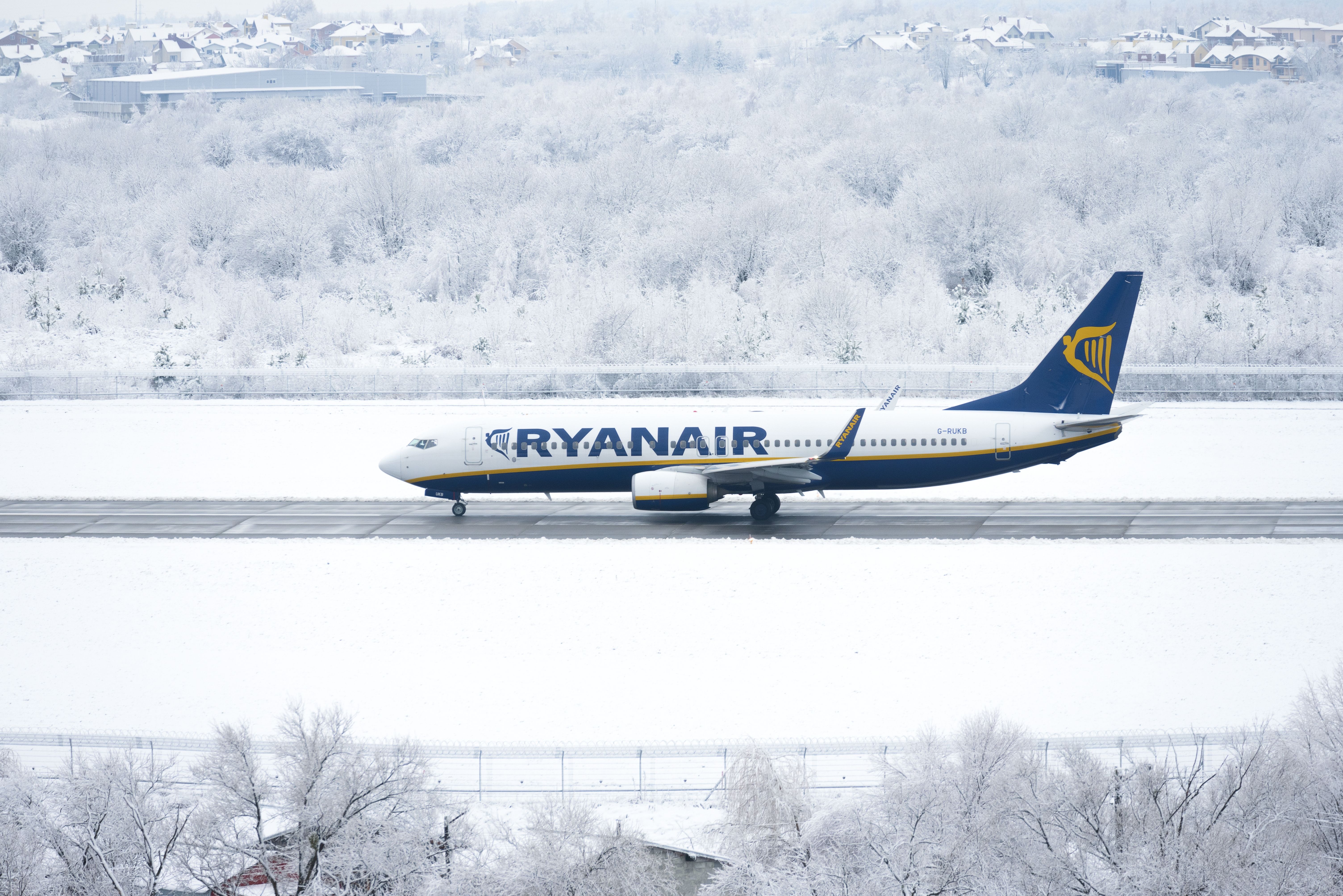 A Ryanair Boeing 737 landing on a snowy runway.