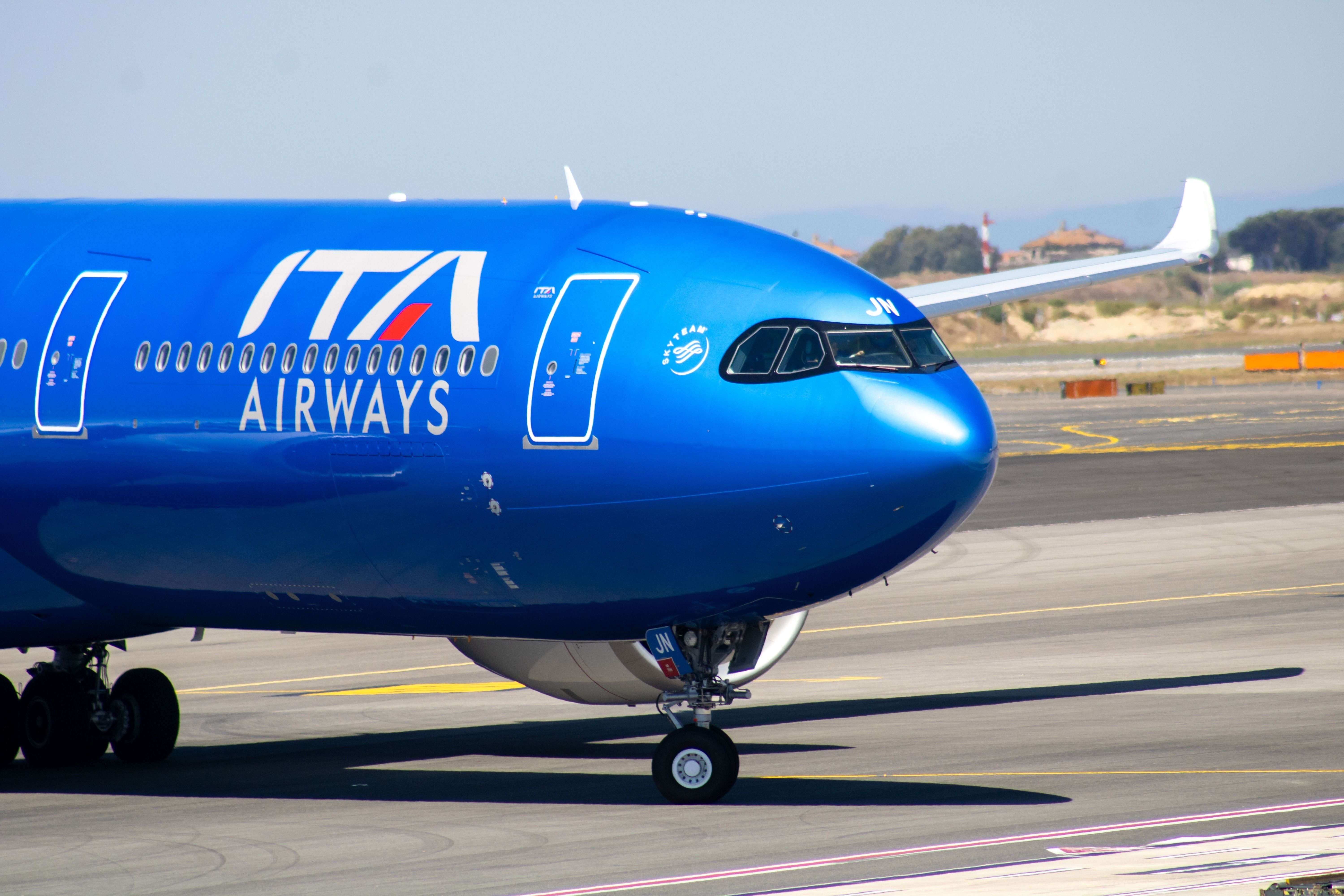 An ITA Airways Airbus A330neo on an airport apron.