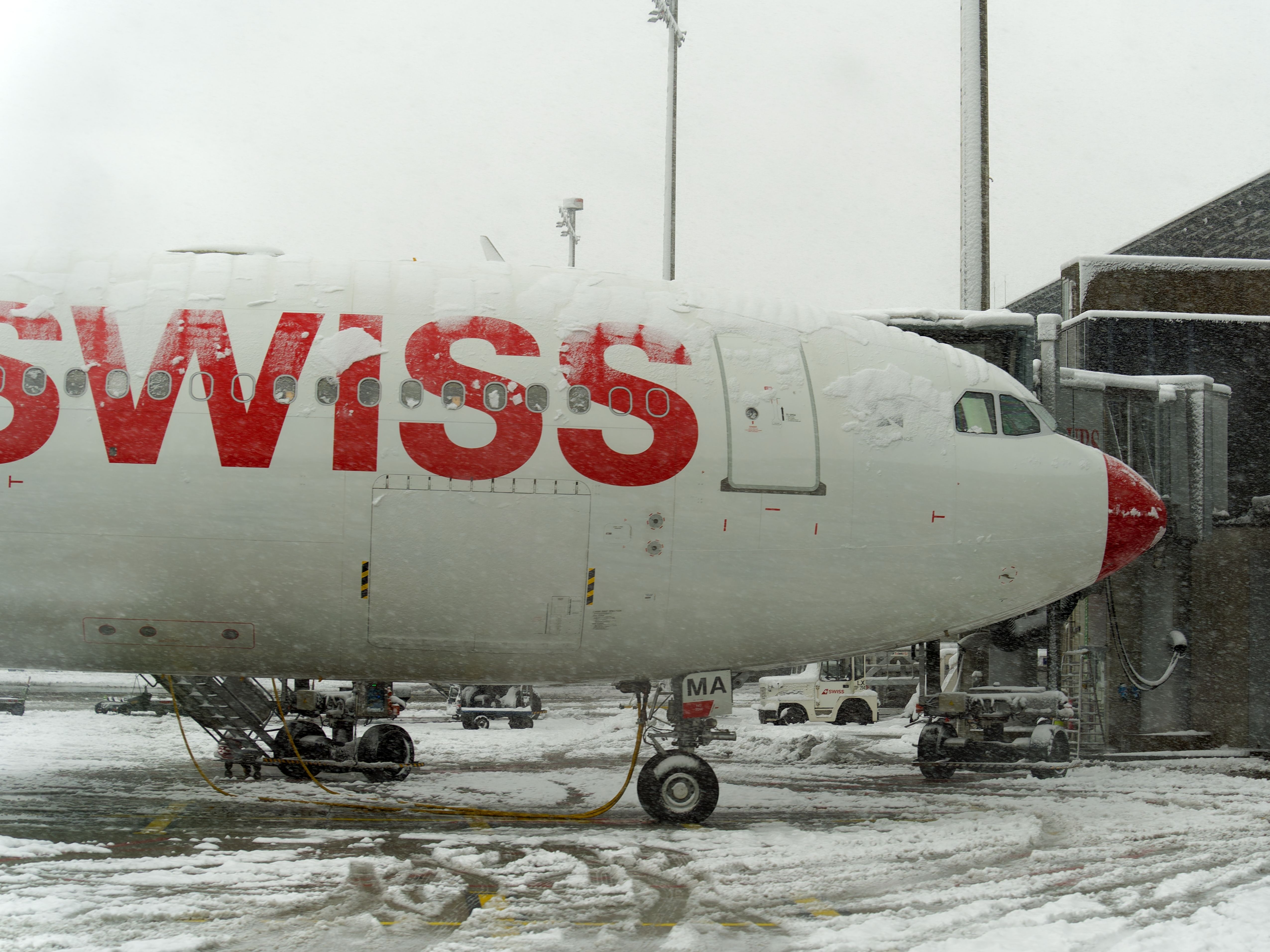 A Swiss Airbus A340-300 parked on a snowy airport apron.