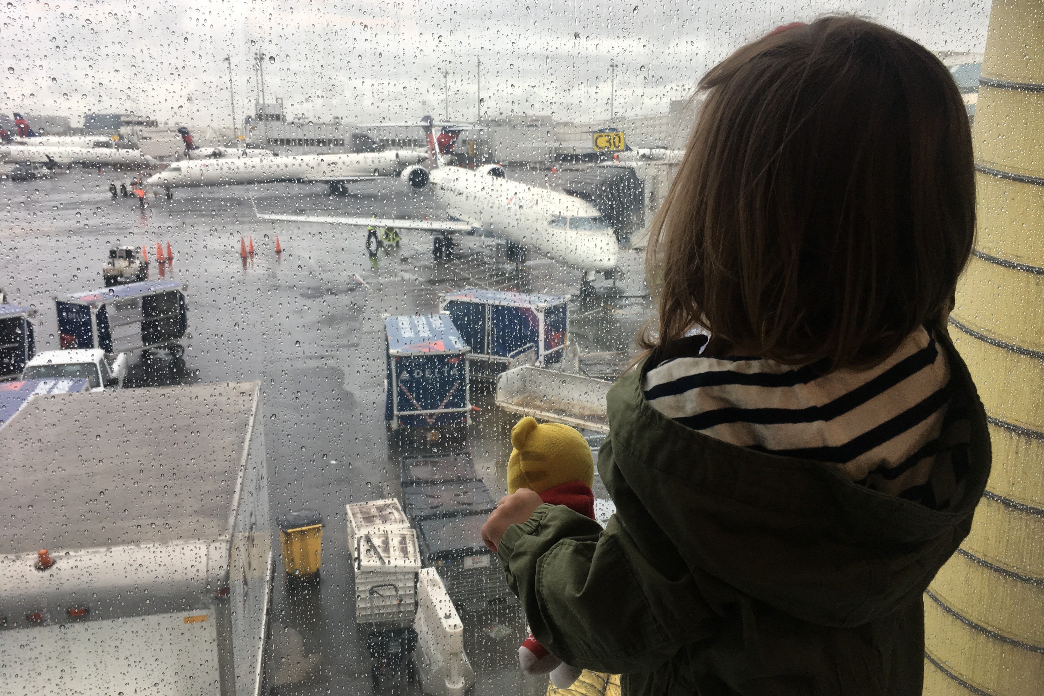 Child With Stuffed Animal Looking At Planes