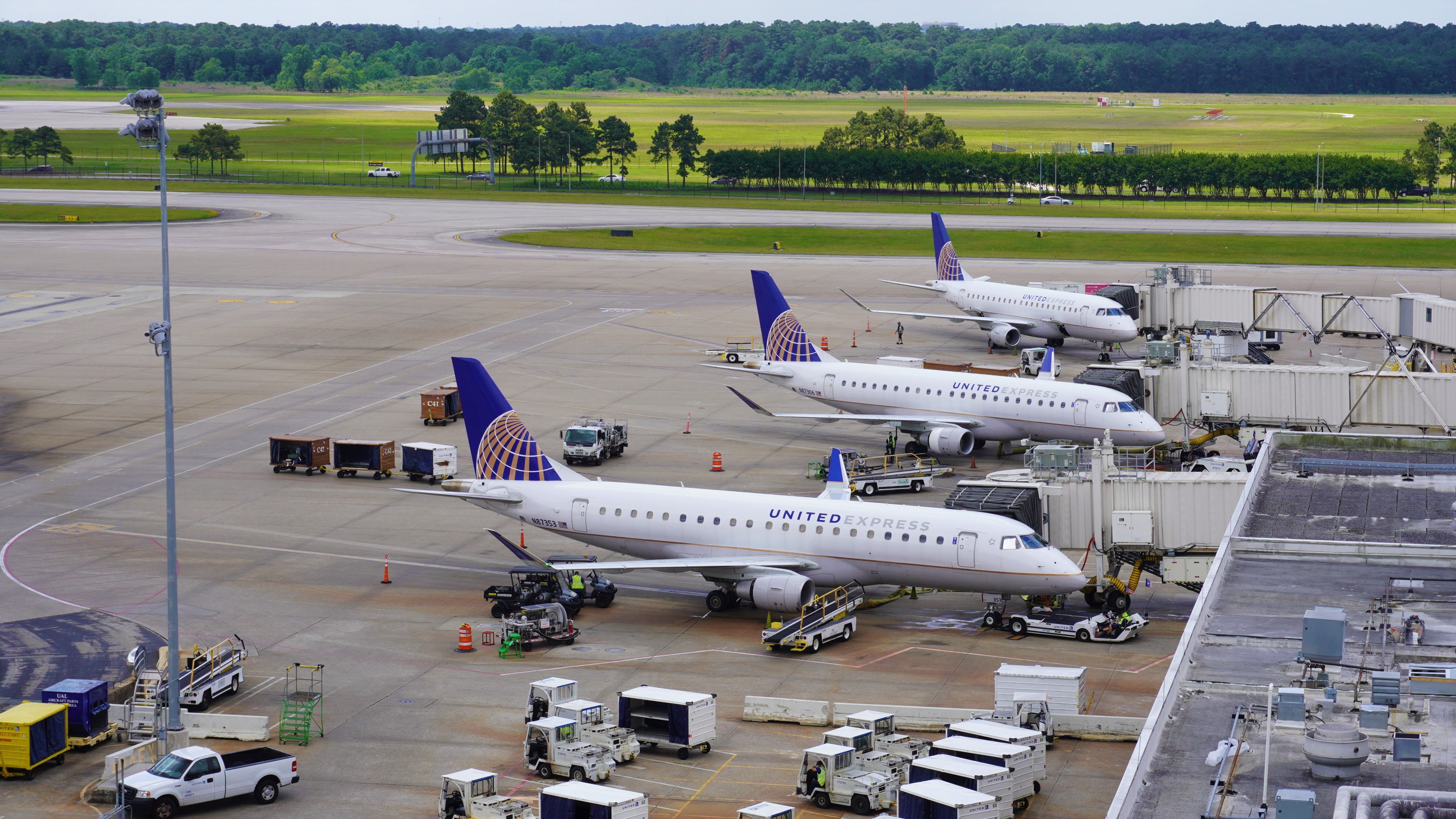Three United Express aircraft parked at airport gates.