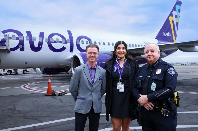 Avelo AIrlines flight crew pose with police officer infront of aircraft 