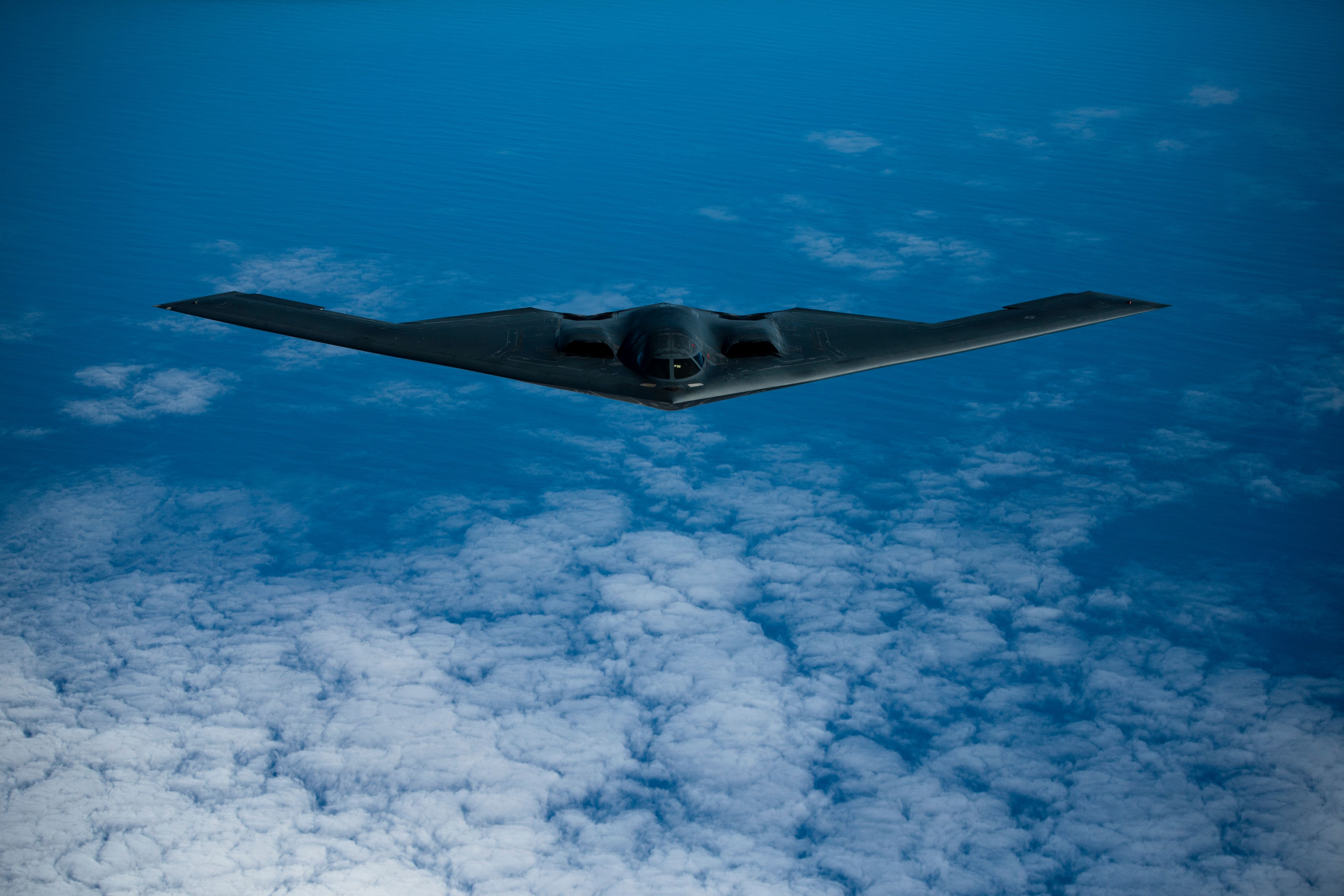 A B-2 Spirit bomber flying above the clouds.