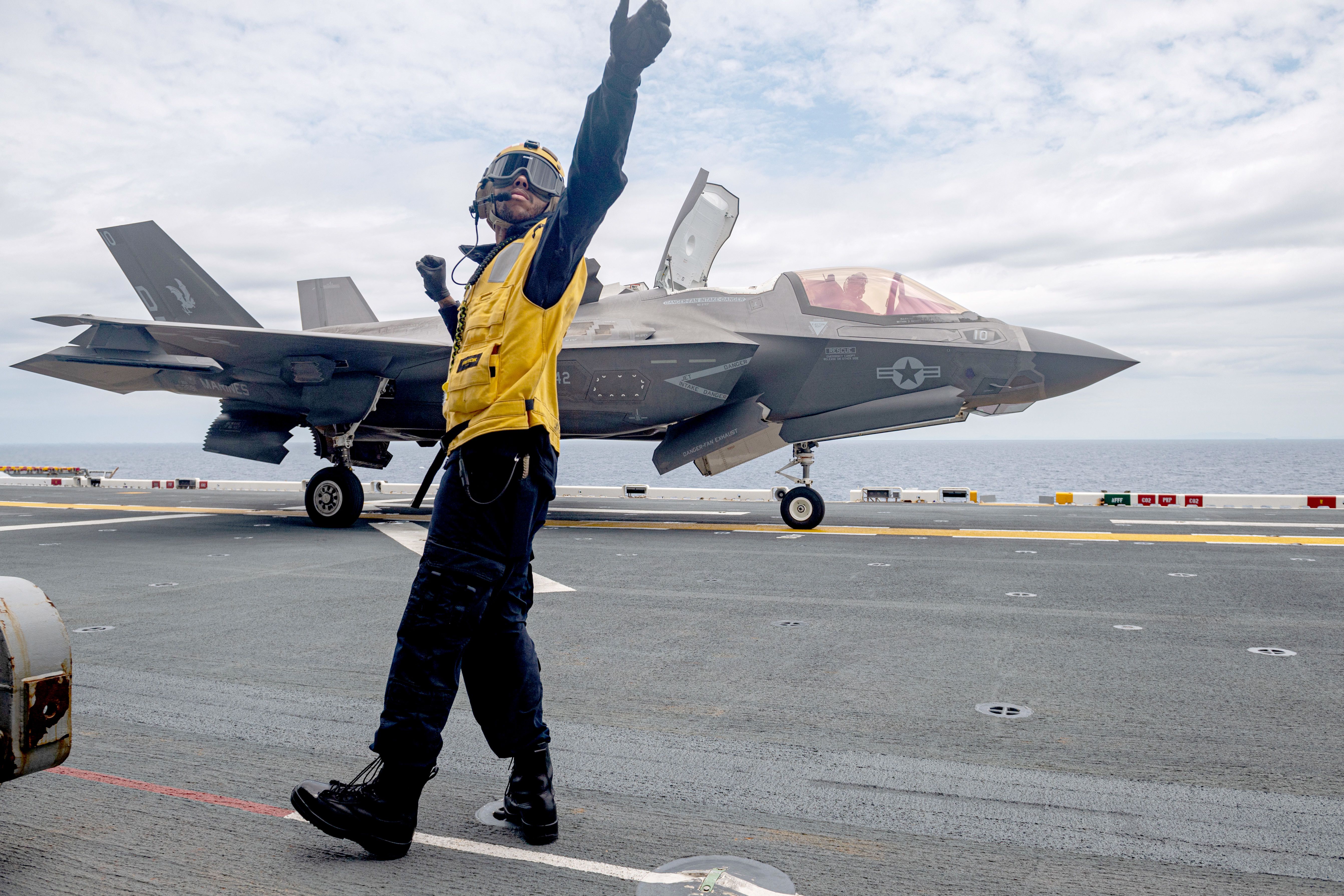 An F-35B Lightning II being prepared to take off from an aircraft carrier.