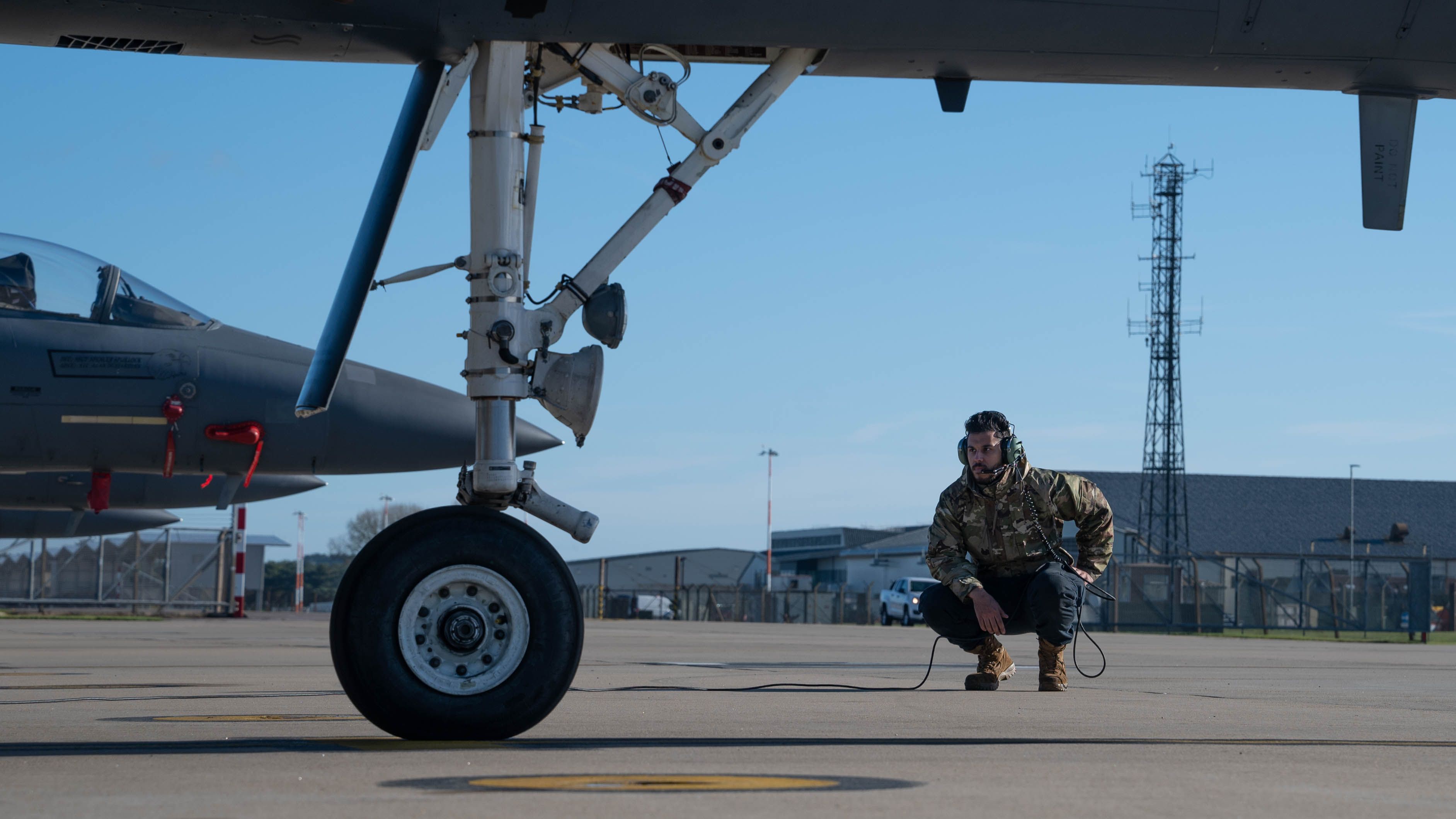 A weapons technician performing preflight checks at a military air field.
