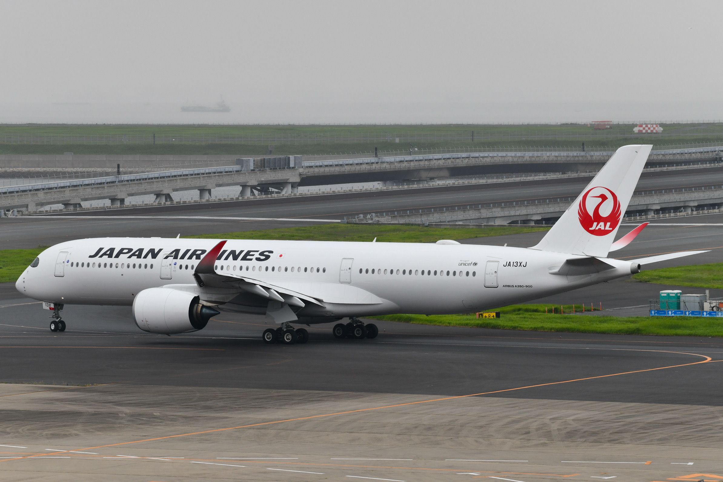 A Japan Airlines A350-941 on an airport apron.