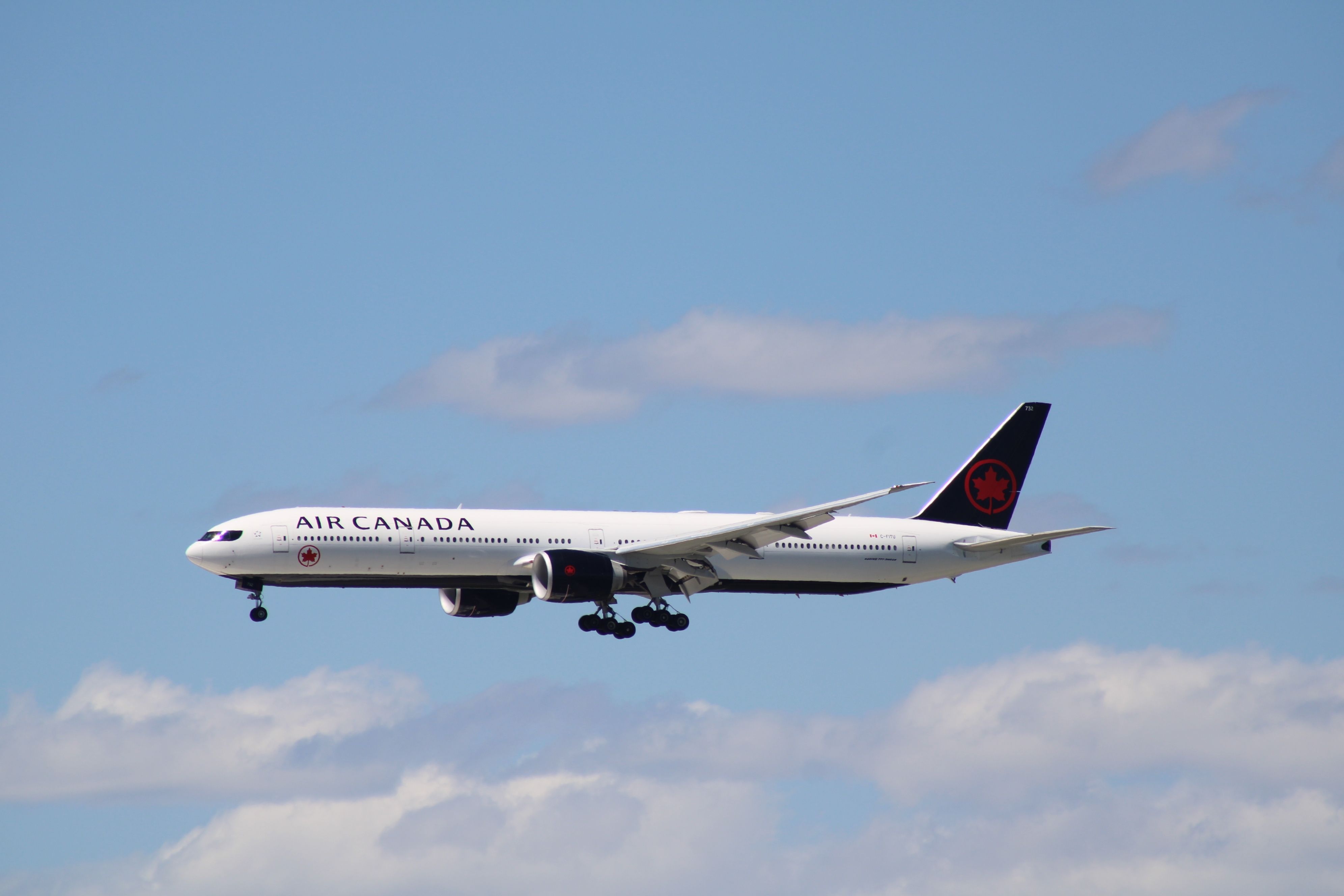 An Air Canada Boeing 777-300ER flying in the sky.