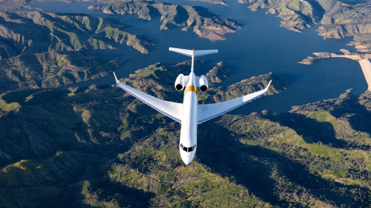 A Bombardier Global 7500 flying over mountainous terrain.