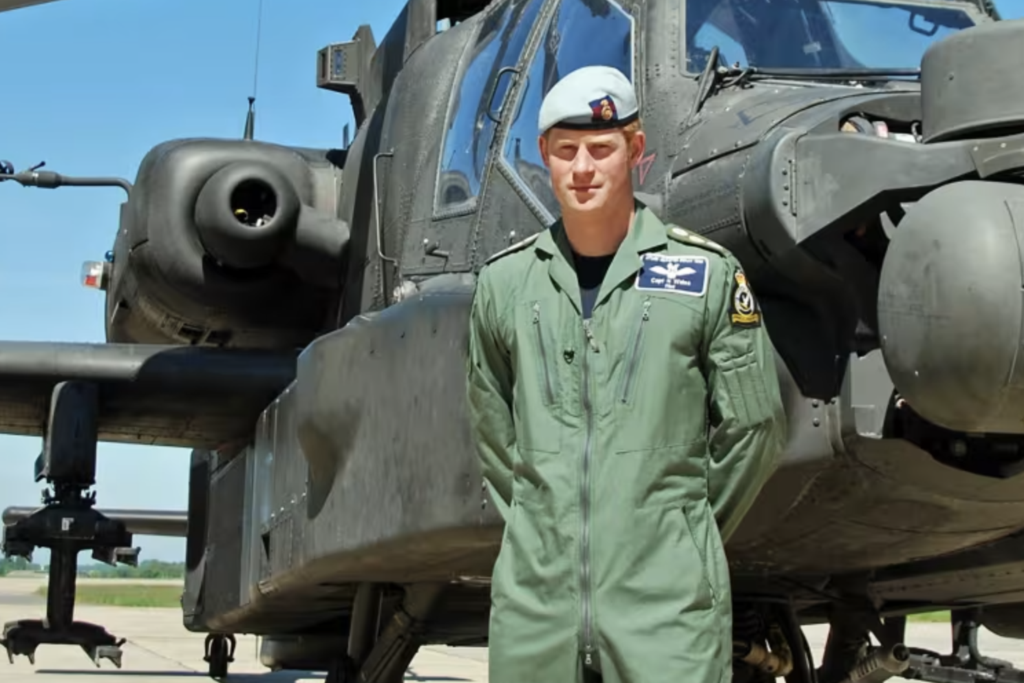 Prince Harry standing in front of an Apache