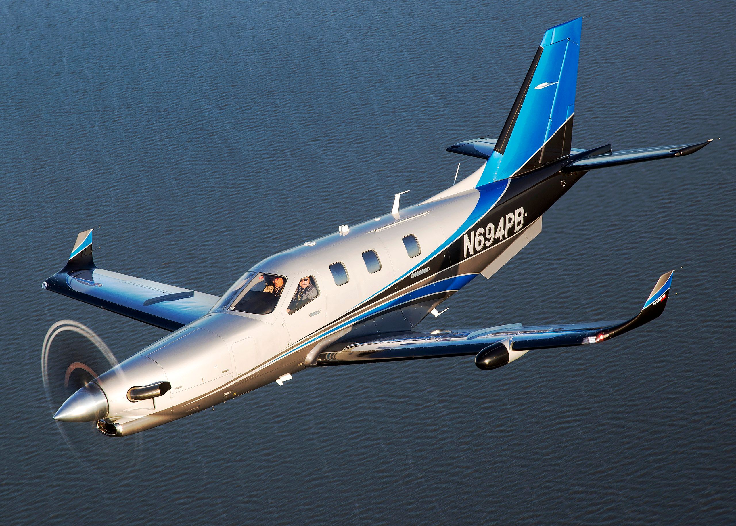 A Daher Socata TBM 900 Flying over water.