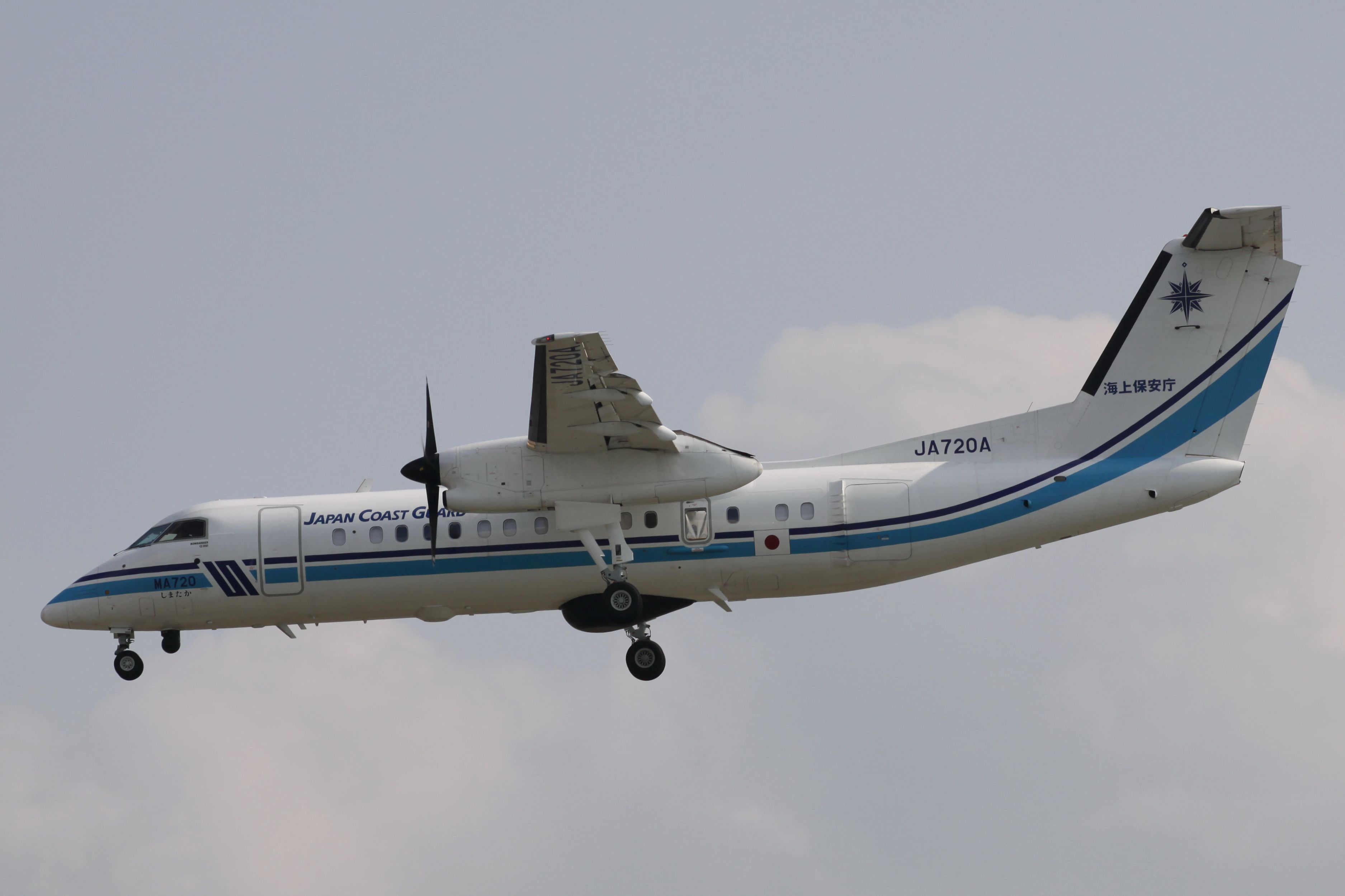 A Japan Coast Guard Bombardier Dash 8 flying in the sky.