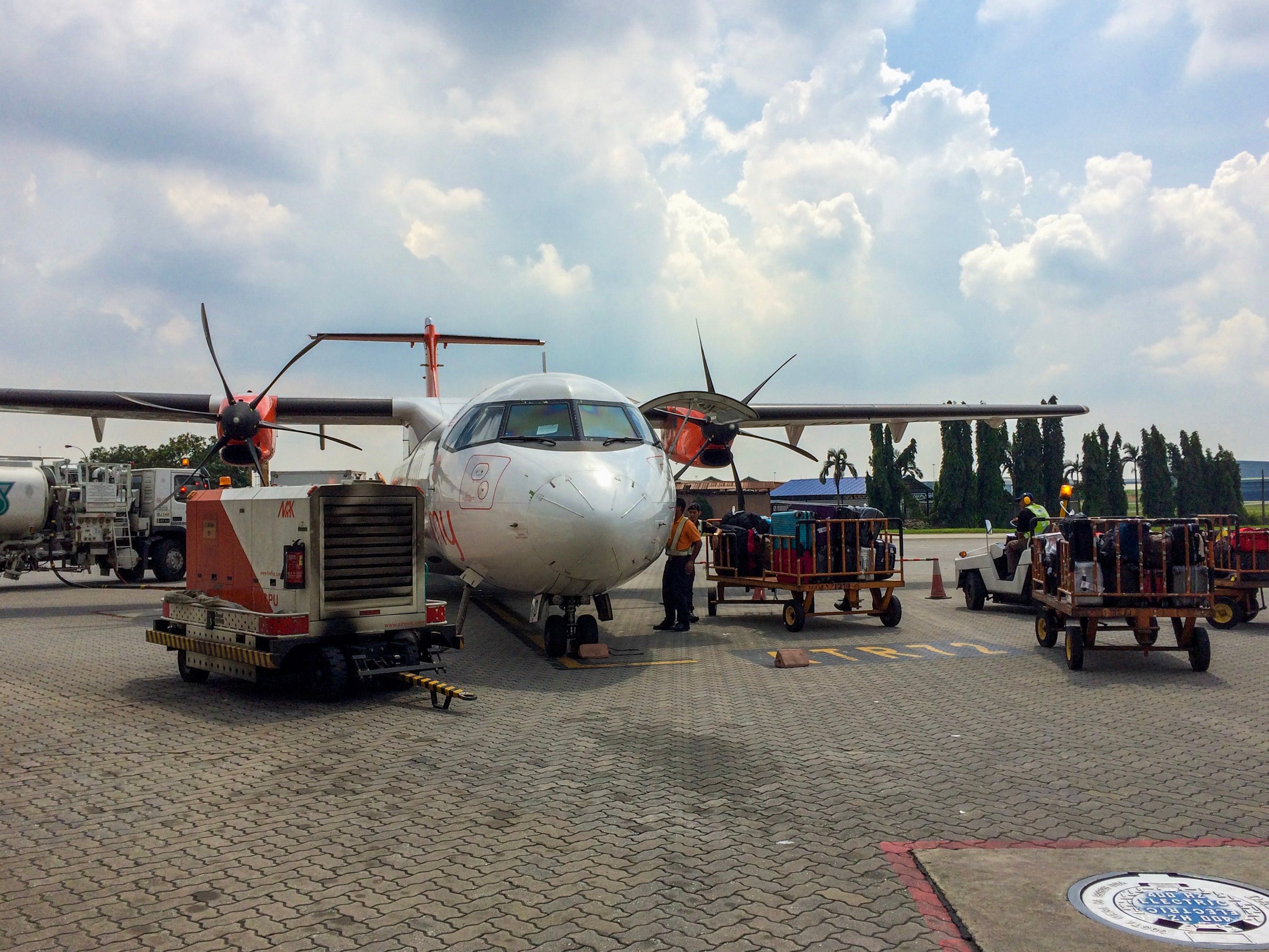 Baggage handlers waiting to upload luggages at Malaysia Subang Airport.