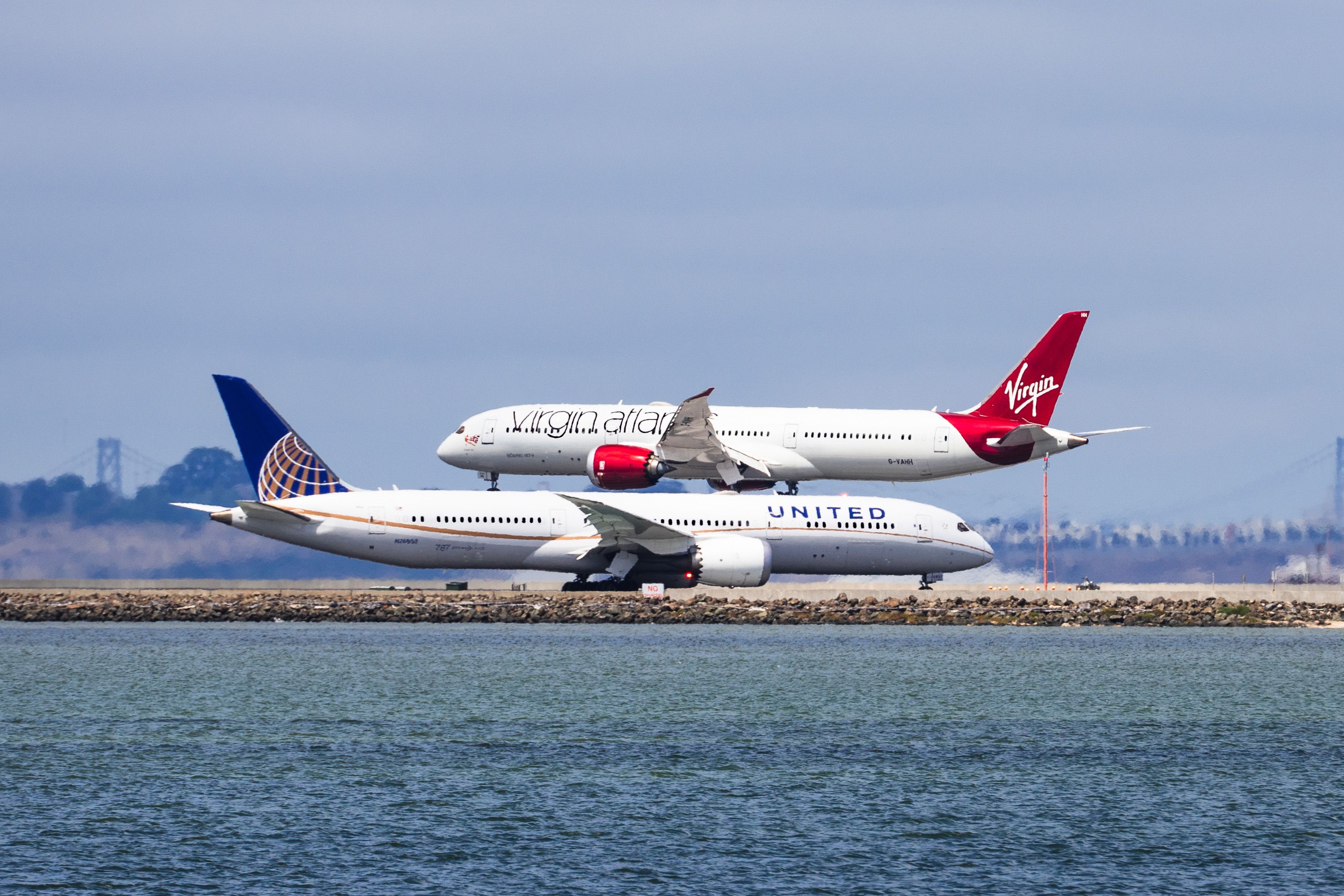 A Virgin Atlantic Boeing 787-9 Dreamliner landing at San Francisco International Airport while a United Airlines 787-9 is waiting to take off at Runway 28L.