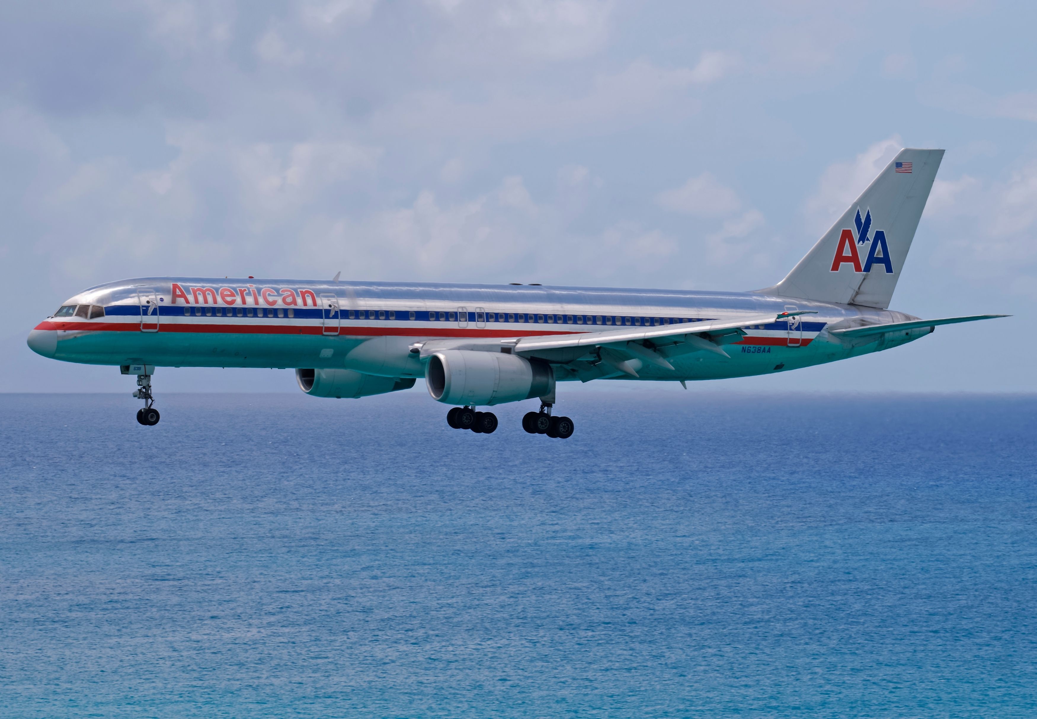 An American Airlines Boeing 757 Flying Just Above A Body Of Water.