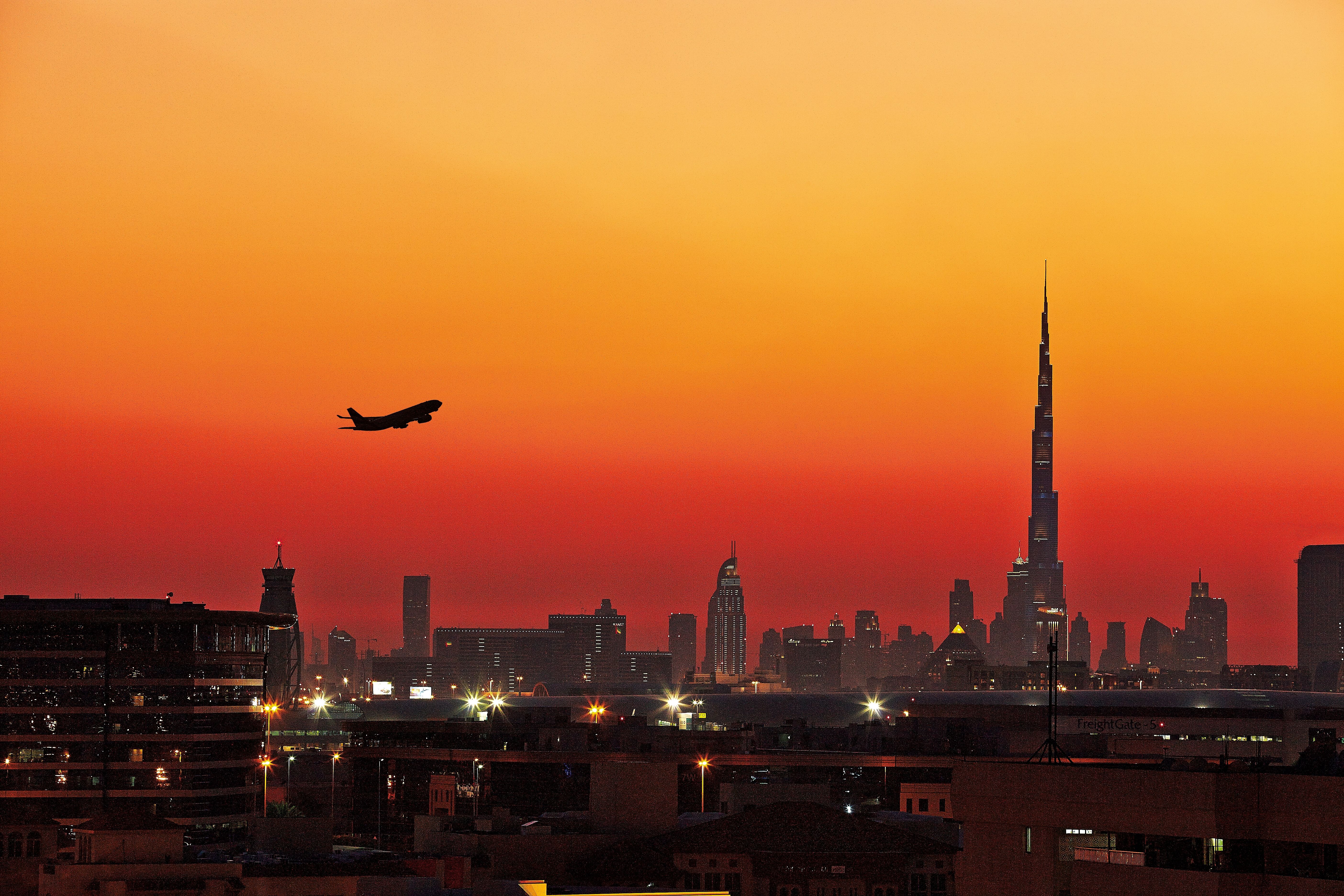 An Airplane Departing From Dubai At Sunset.
