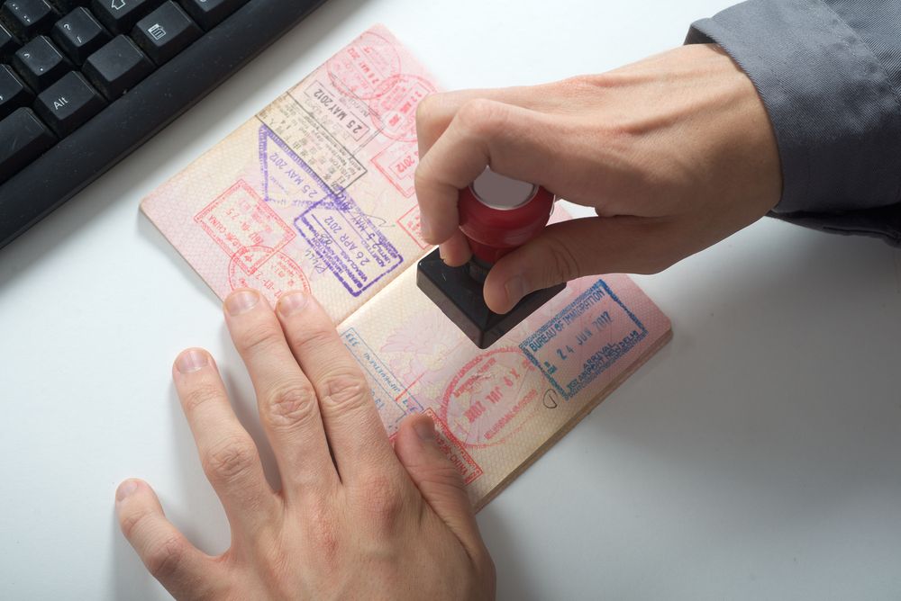 An Immigration control officer stamping a passport.