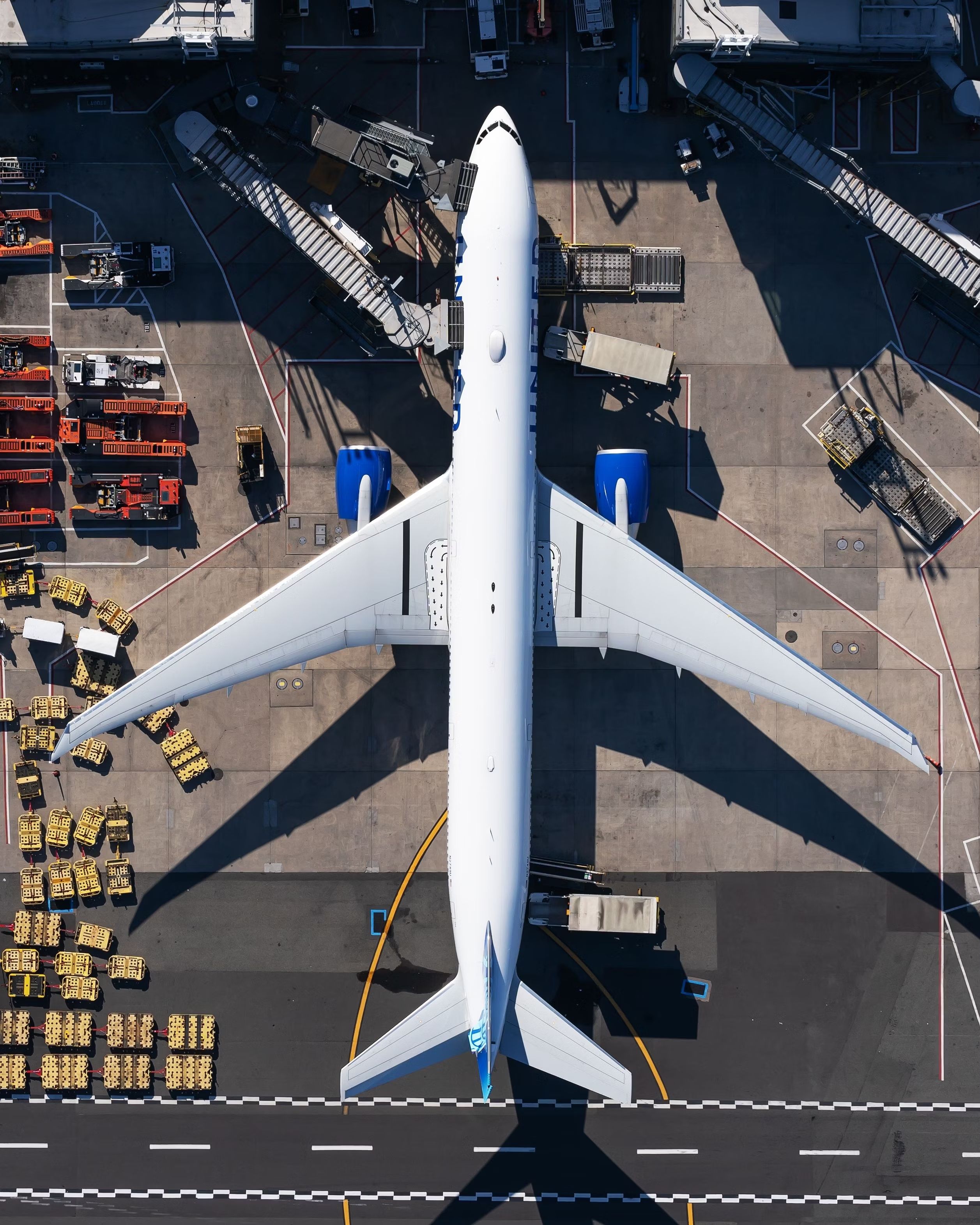 A United Airlines Boeing 777-300ER parked at a gate as seen from above.