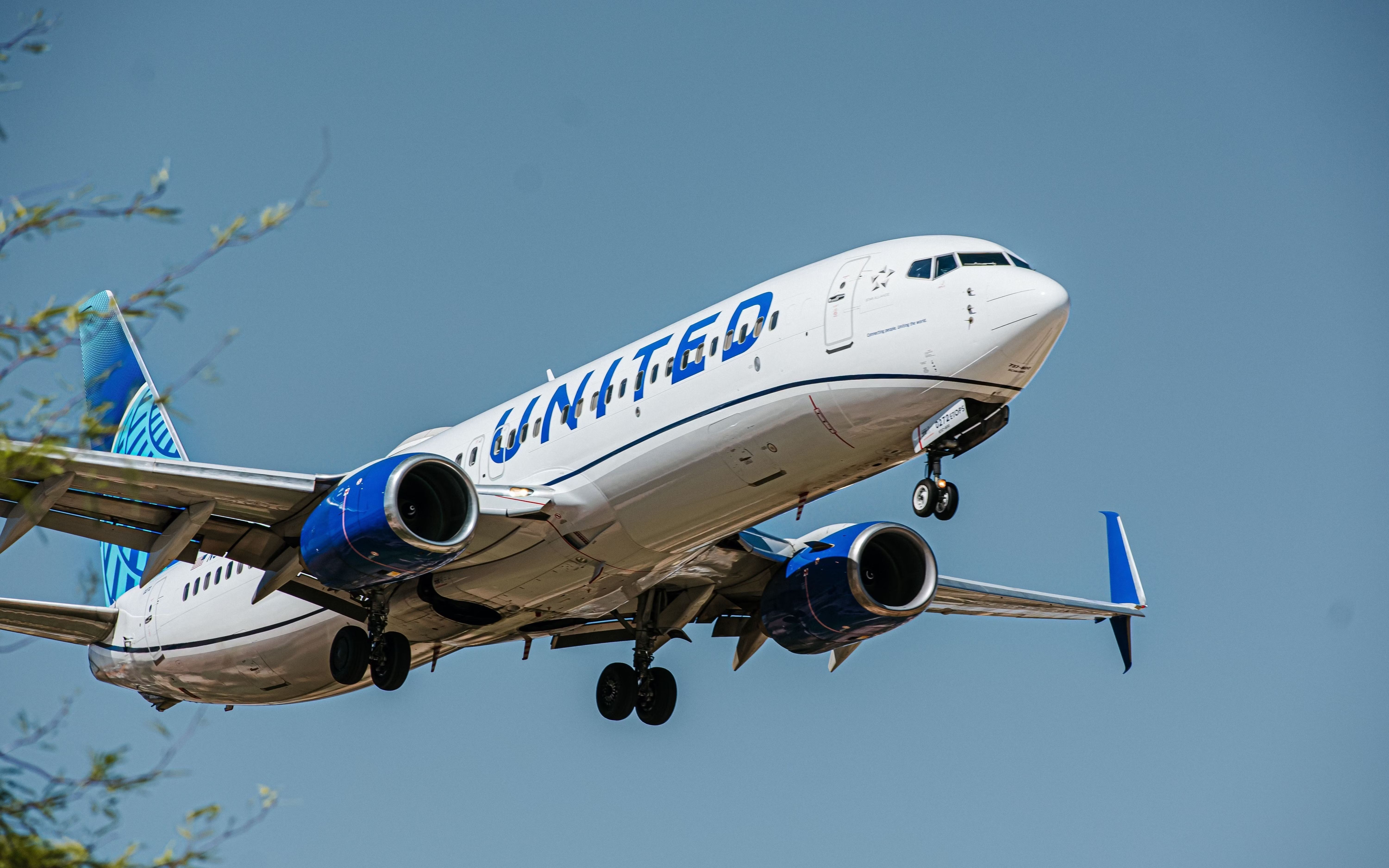 A United Boeing 737-800 flying low to the ground.