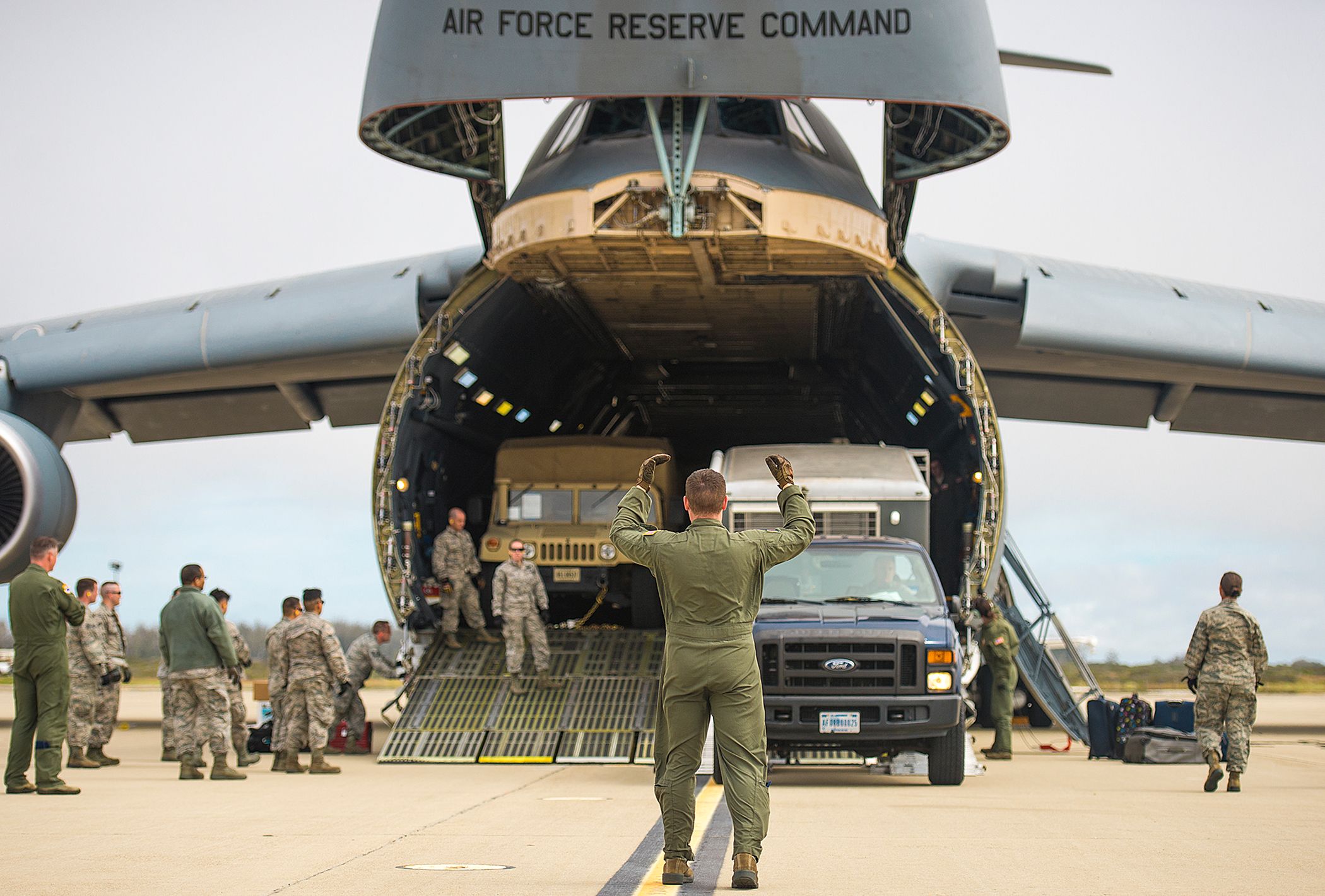 Airmen unload vehicles from a C-5M Super Galaxy aircraft.