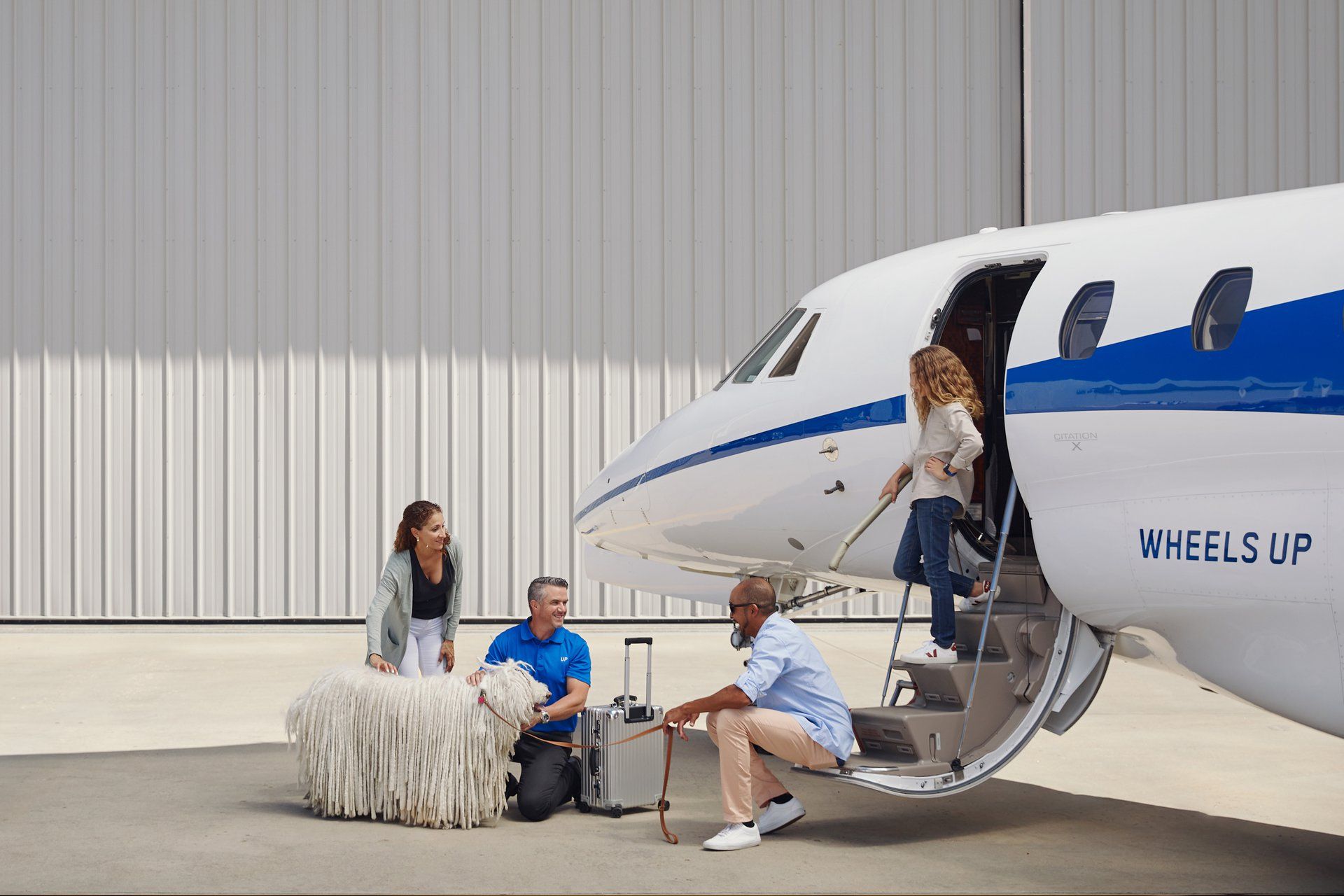 A family boarding a Wheels Up business aircraft.