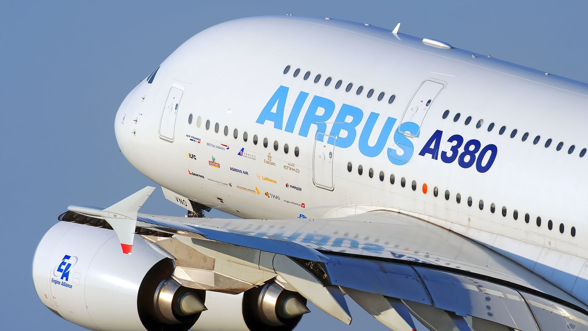 A closeup of an Airbus A380 in house livery flying in the sky.