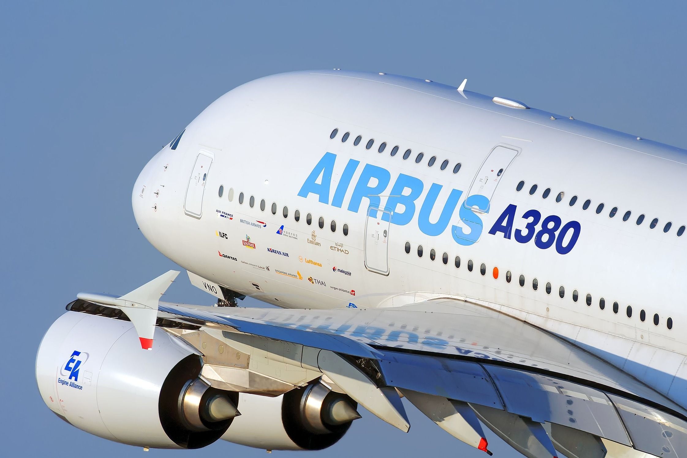 A closeup of an Airbus A380 in house livery flying in the sky.