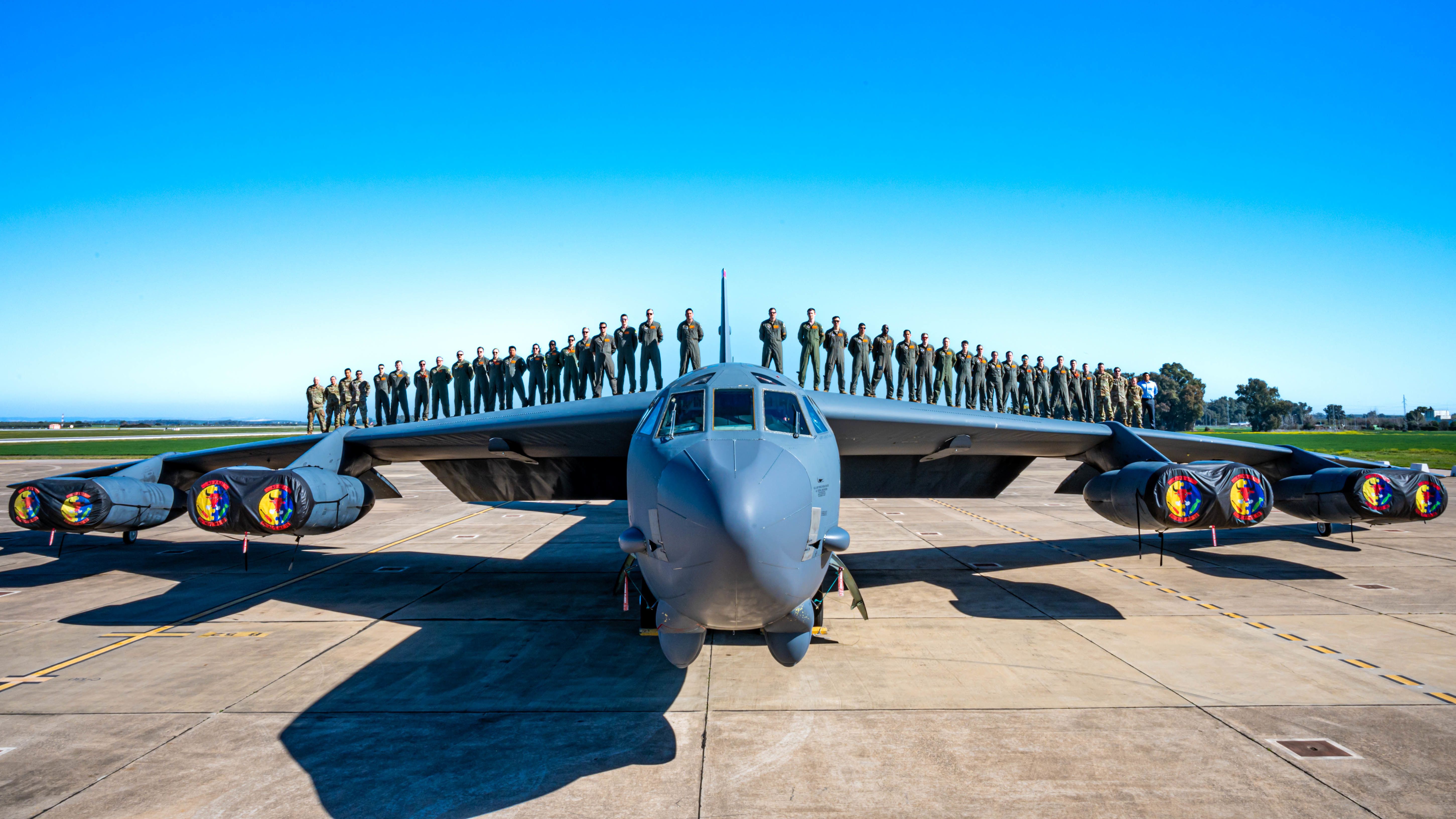 Dozens of airmen standing on top of a Boeing B-52.