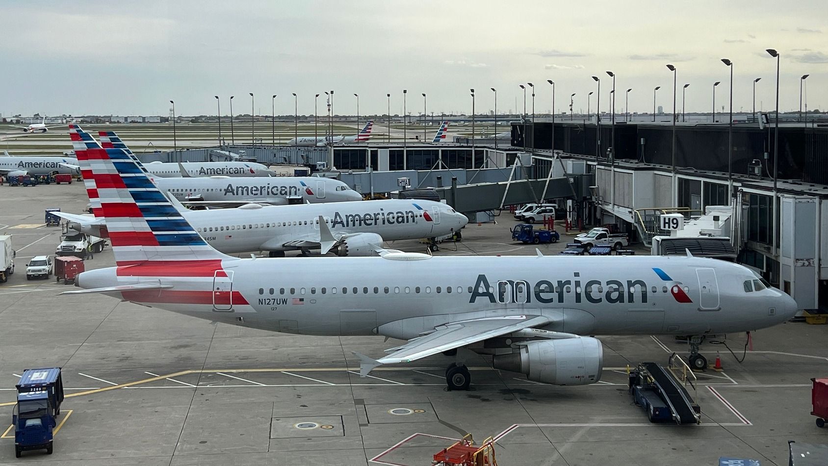 Several American Airlines aircraft parked at gates at Chicago O'Hare International Airport.
