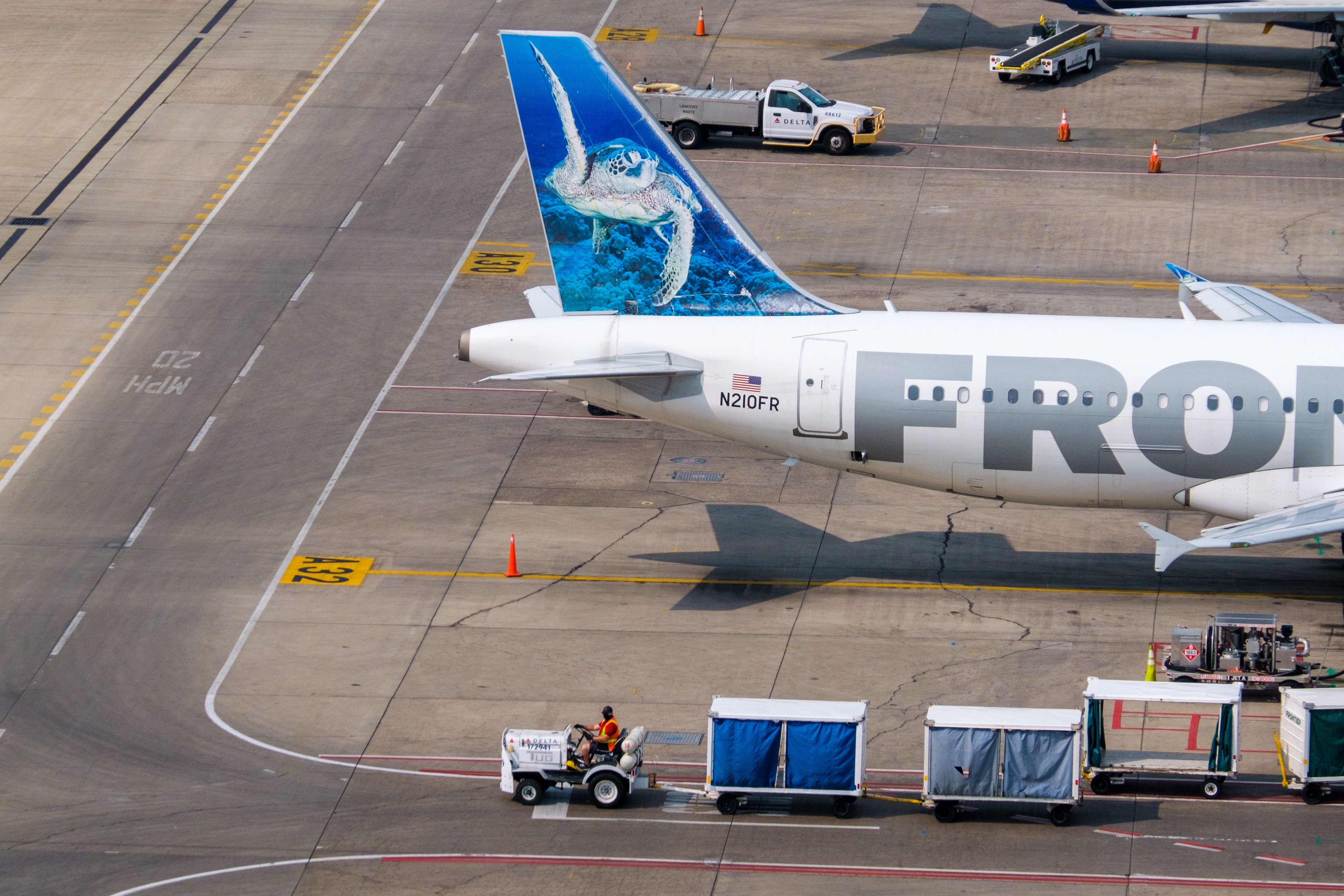 The rear half of a Frontier Airlines aircraft parked on an airport apron.