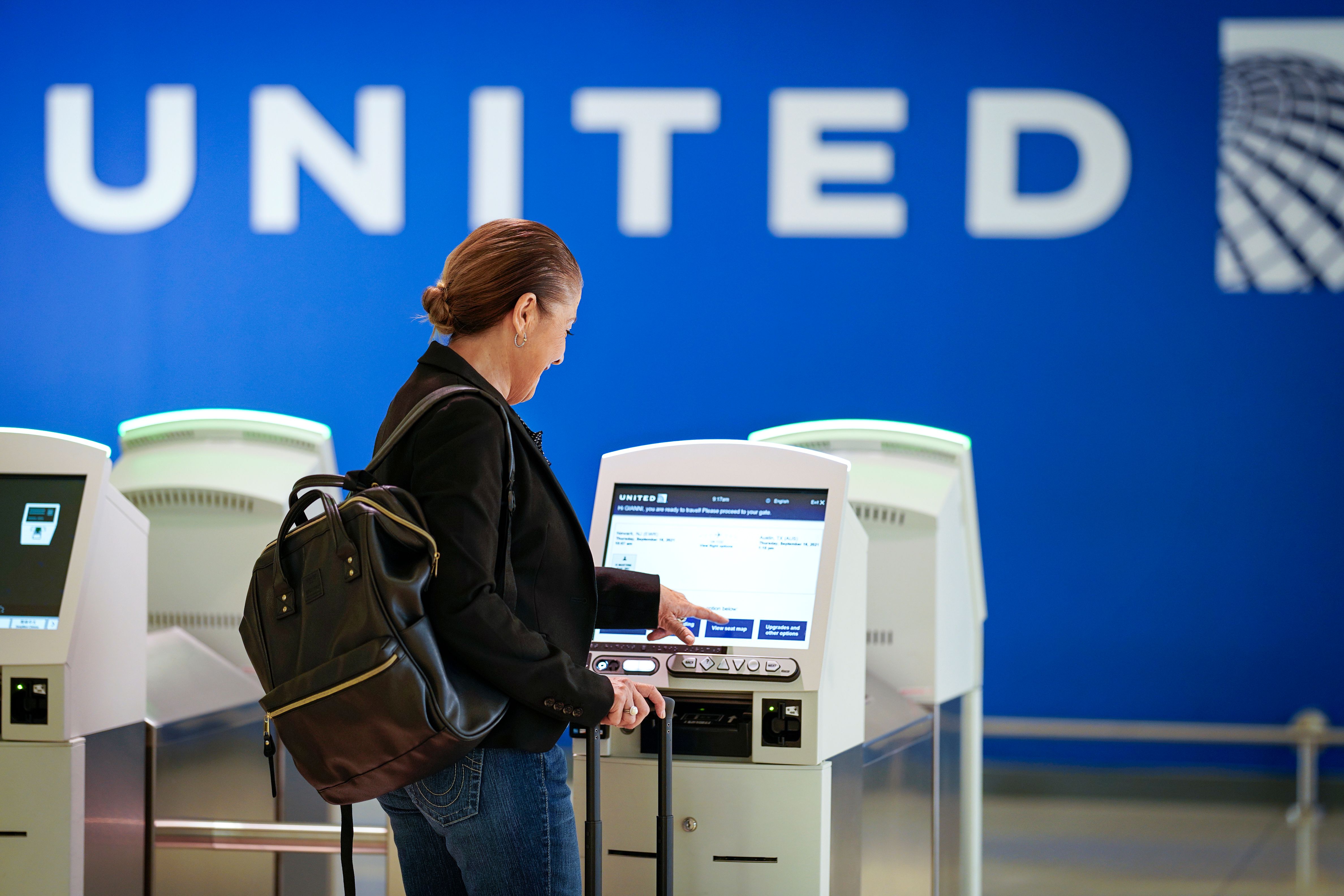 A passneger using a United Airlines Check-In Kiosk.